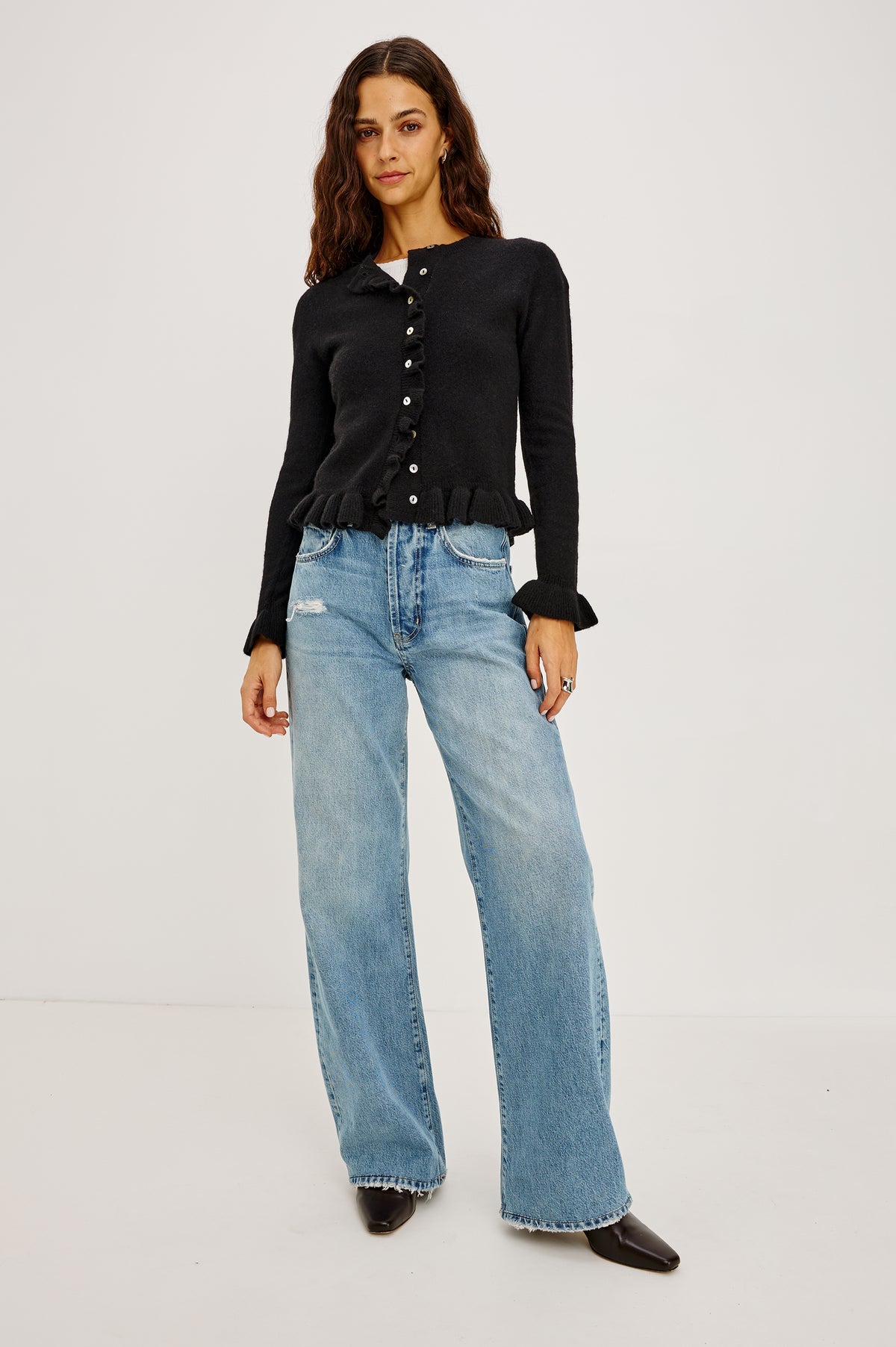 Mandy Sweater in Cashmere-Cotton-Wool Blend Knit Front Buttons, Long Sleeves, Classic Slightly Cropped Fit, and Ribbed Ruffle Trim in Black Colorway - Front Full Body View Featured on Model.
