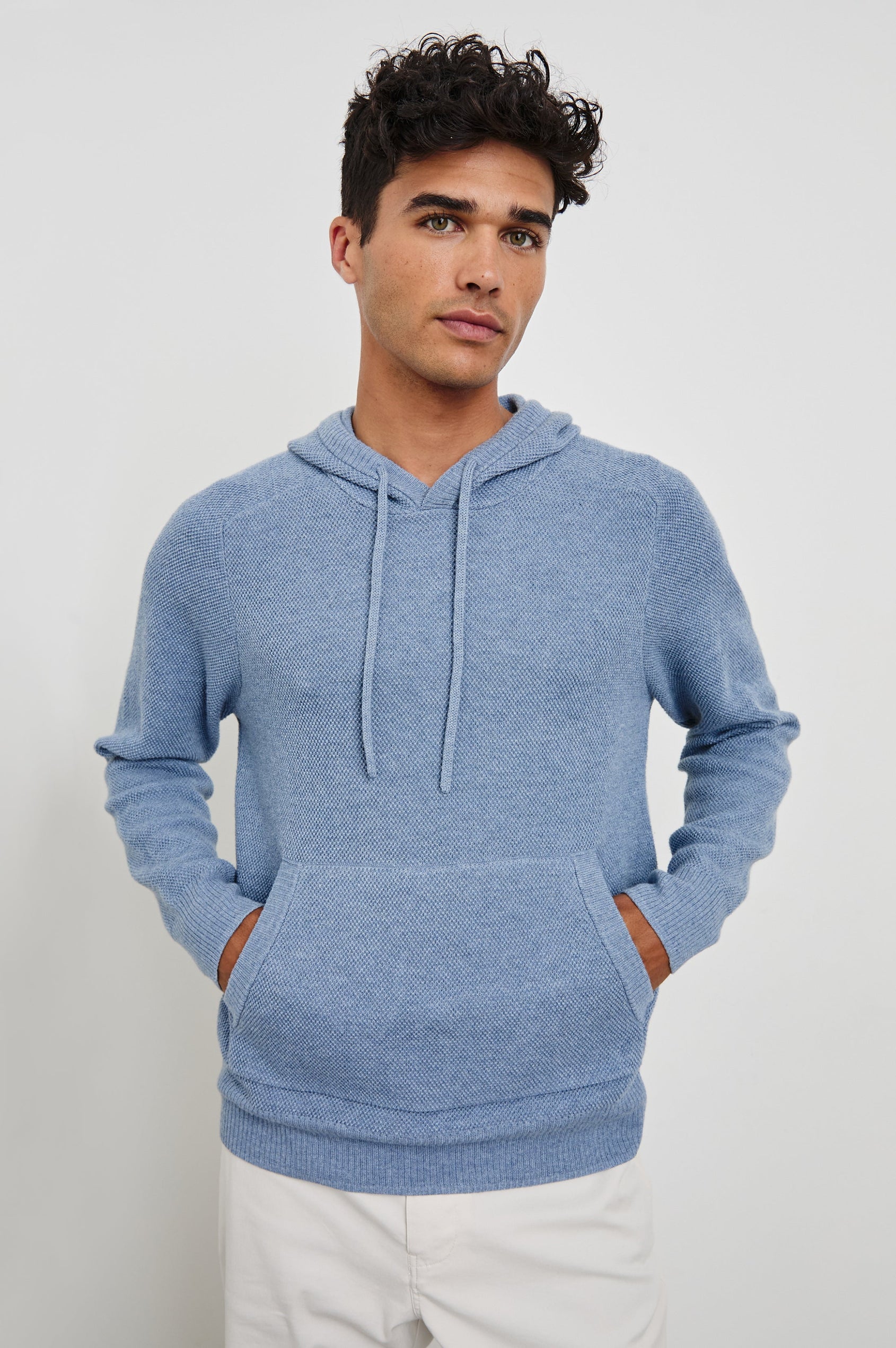 Matador knit sweater with hoodie, adjustable drawstrings, and dual side front pocket in Light Blue Heather - front view on model, hands in pocket