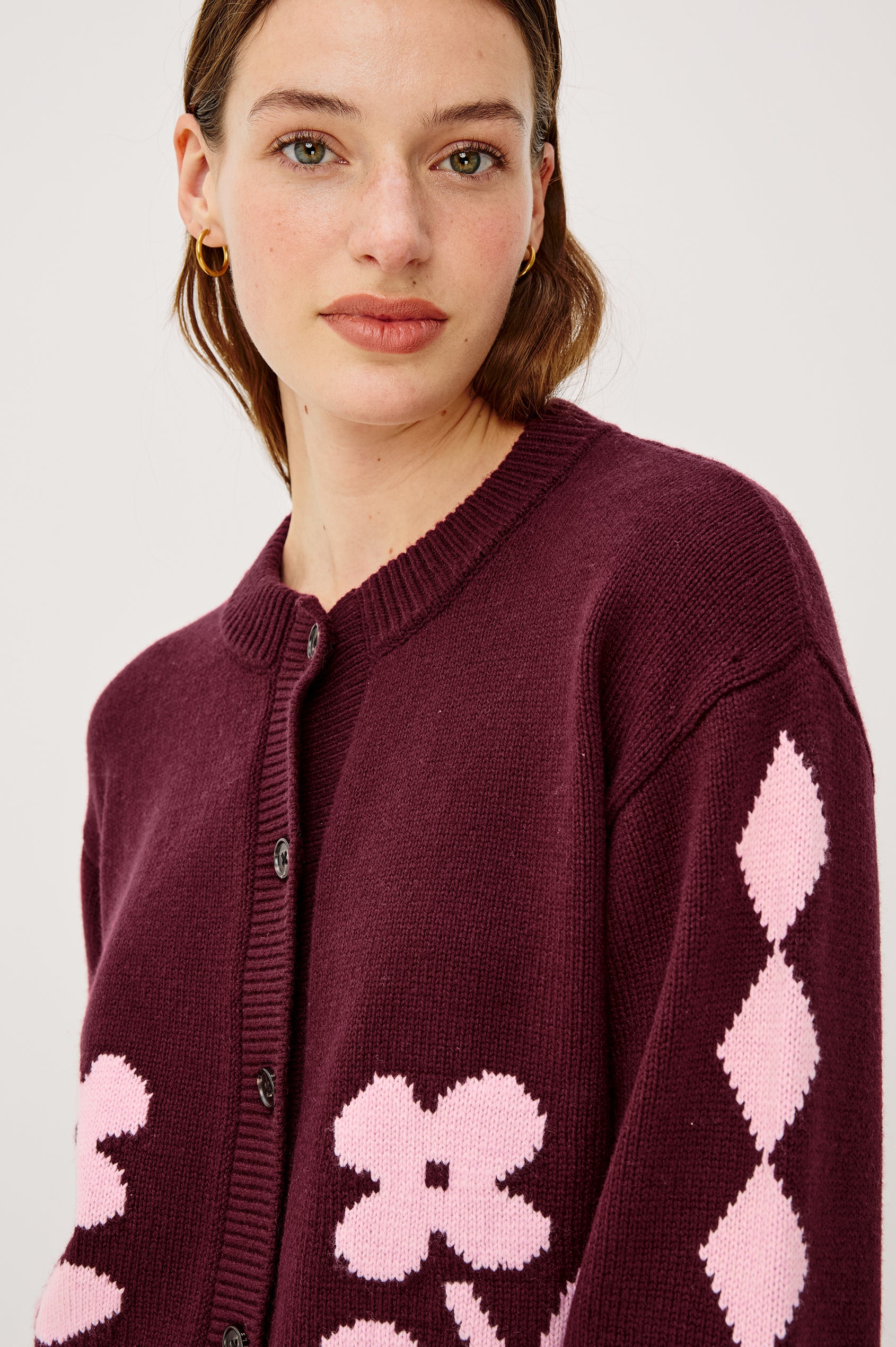 Mavie Cardigan in Wool Blend With Loose Relaxed Fit, Contrast Front Floral Motifs, Diamond Motifs at Long Sleeves, Crew Neckline, Front Buttons, and Ribbed Trim in Garnet Daisy Colorway - Upper Body Close Up Front View Featured on Model