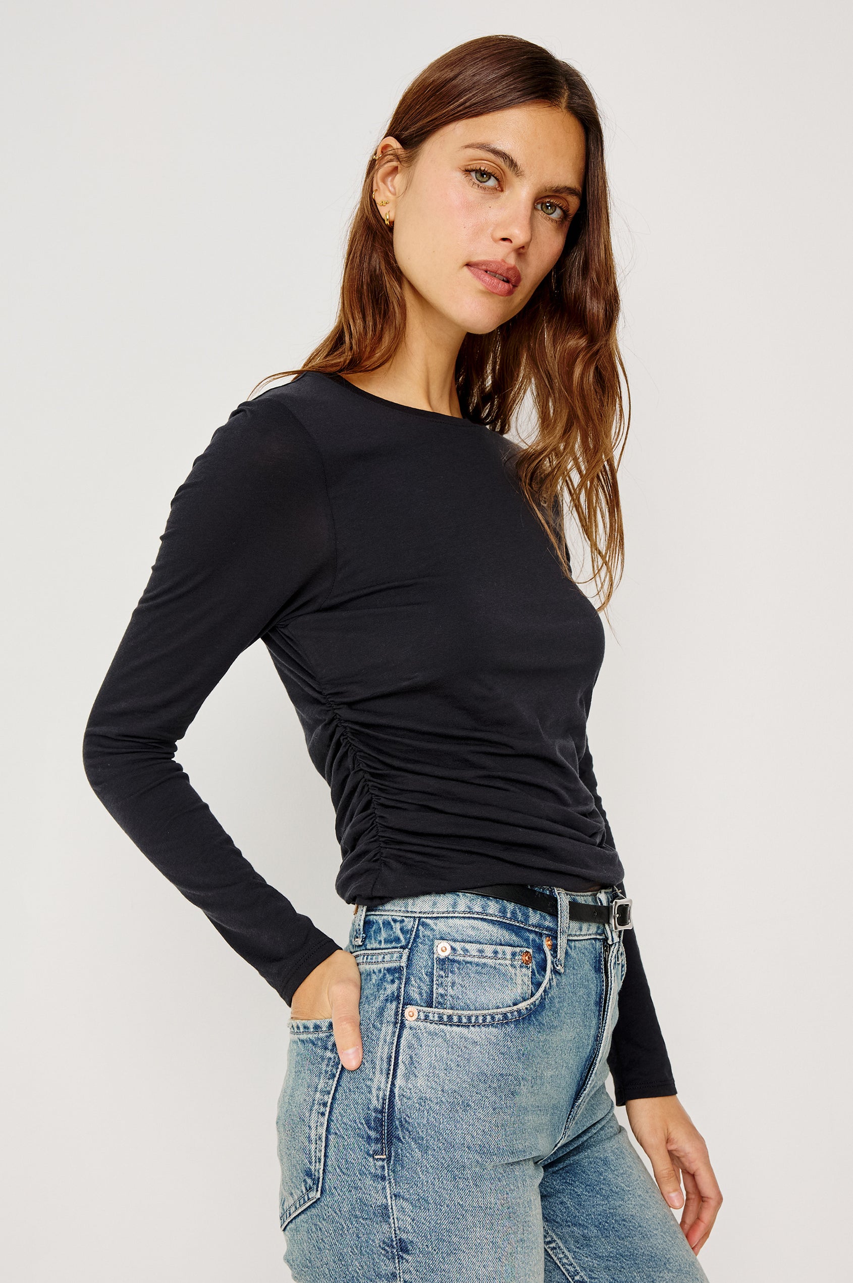 Melle Fitted Top in Organic Cotton With Crew Neckline, Side Shirring, and Long Sleeves in Black Colorway - Upper Body Side View Featured on Model