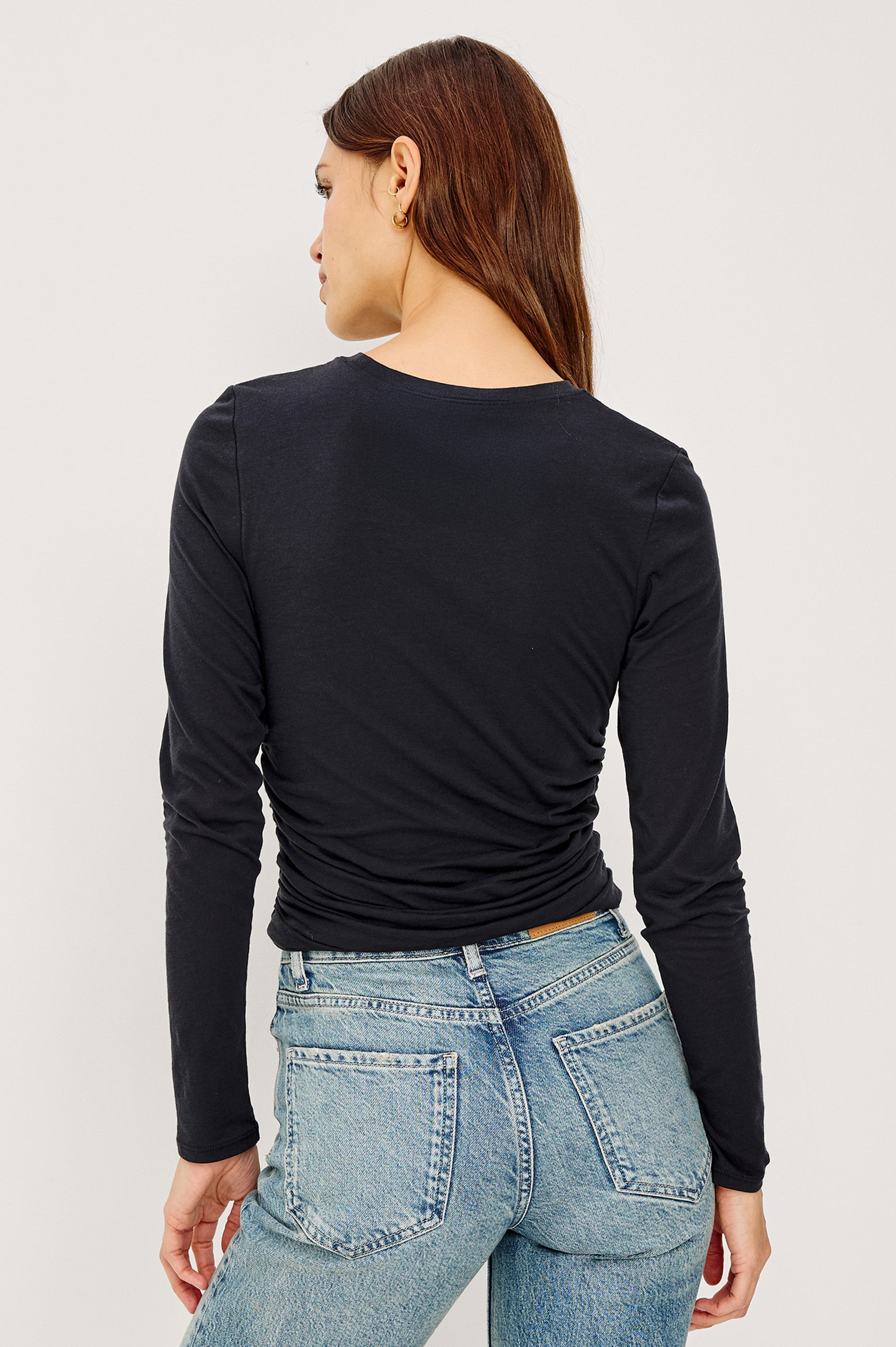 Melle Fitted Top in Organic Cotton With Crew Neckline, Side Shirring, and Long Sleeves in Black Colorway - Upper Body Back View Featured on Model