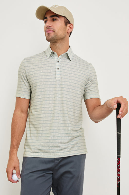 Merced short sleeve athletic Golf Polo with two button placket and collar in Sashiko Border White - front view on model wearing hat, holding golf club and ball 