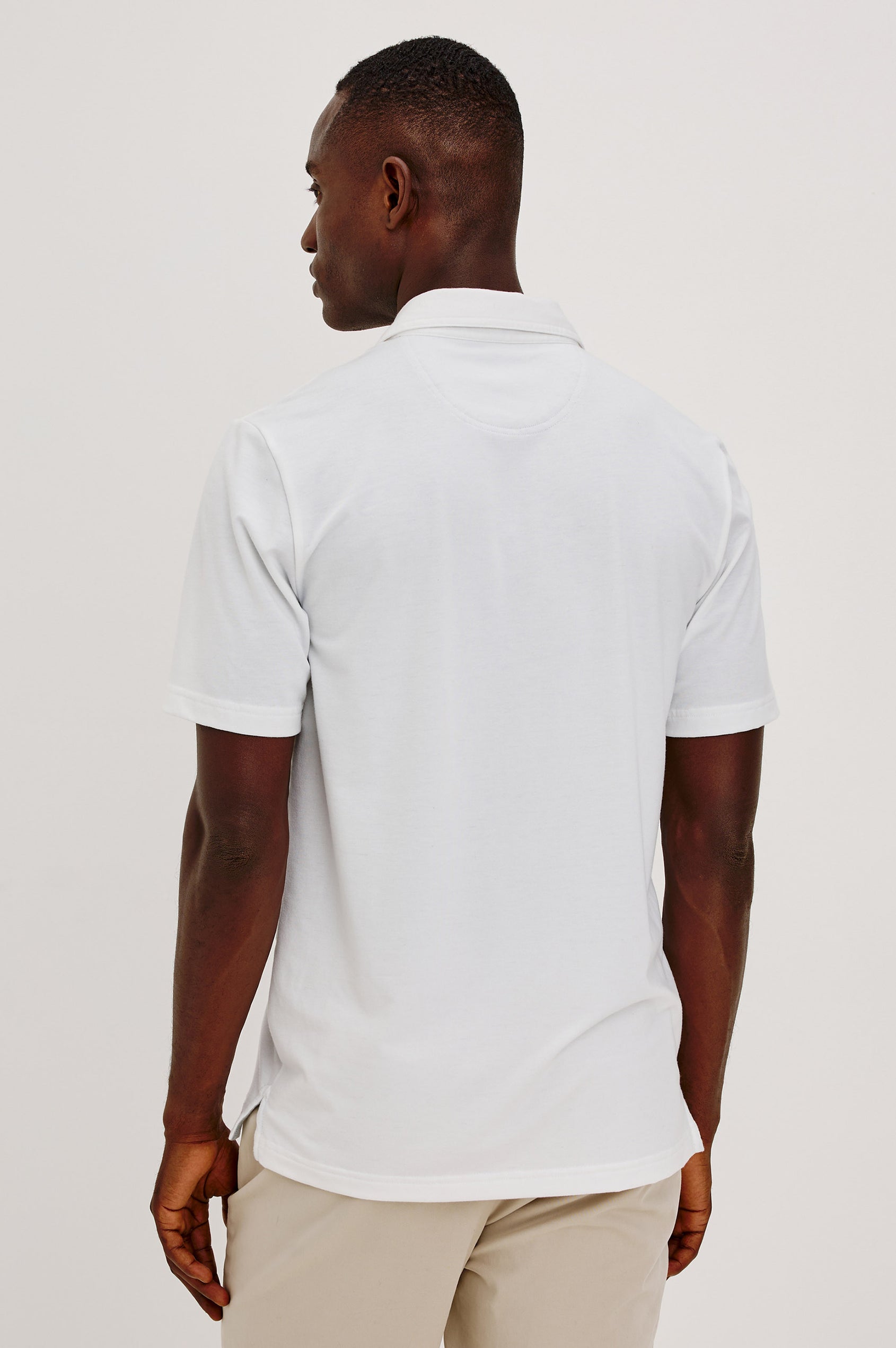 Merced Golf Polo in TENCEL™-Poly Stretch Blend With Moisture-Wicking Properties, Collar, Quarter-Placket, and Short Sleeves in White Colorway - Upper Body Back View Featured on Model