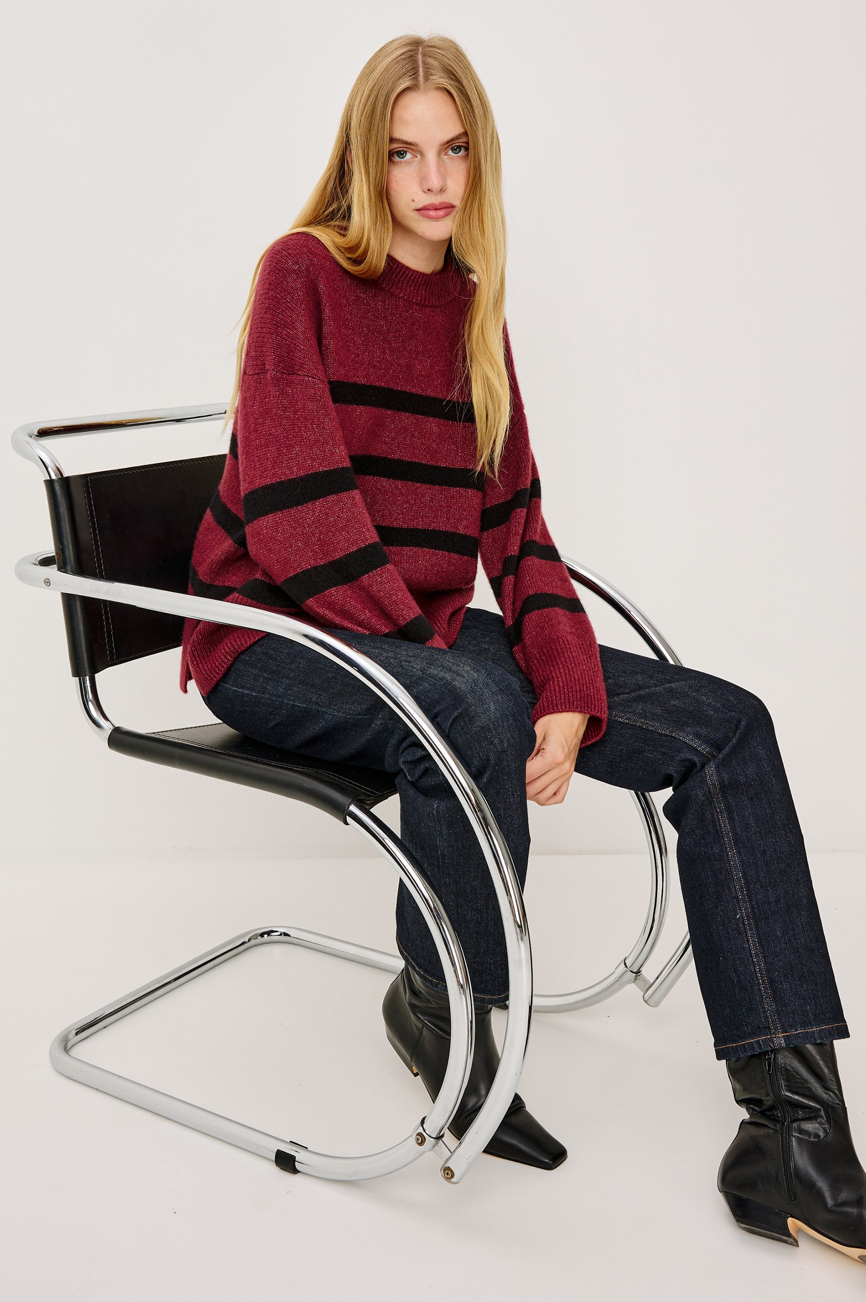 Miranda Sweater in Cashmere-Silk Blend With Crew Neckline, Ribbed Trim, Dropped Shoulders, Loose Relaxed Fit, and Long Sleeves in Garnet Black Stripe Colorway - Full Body View Featured on Model Sitting