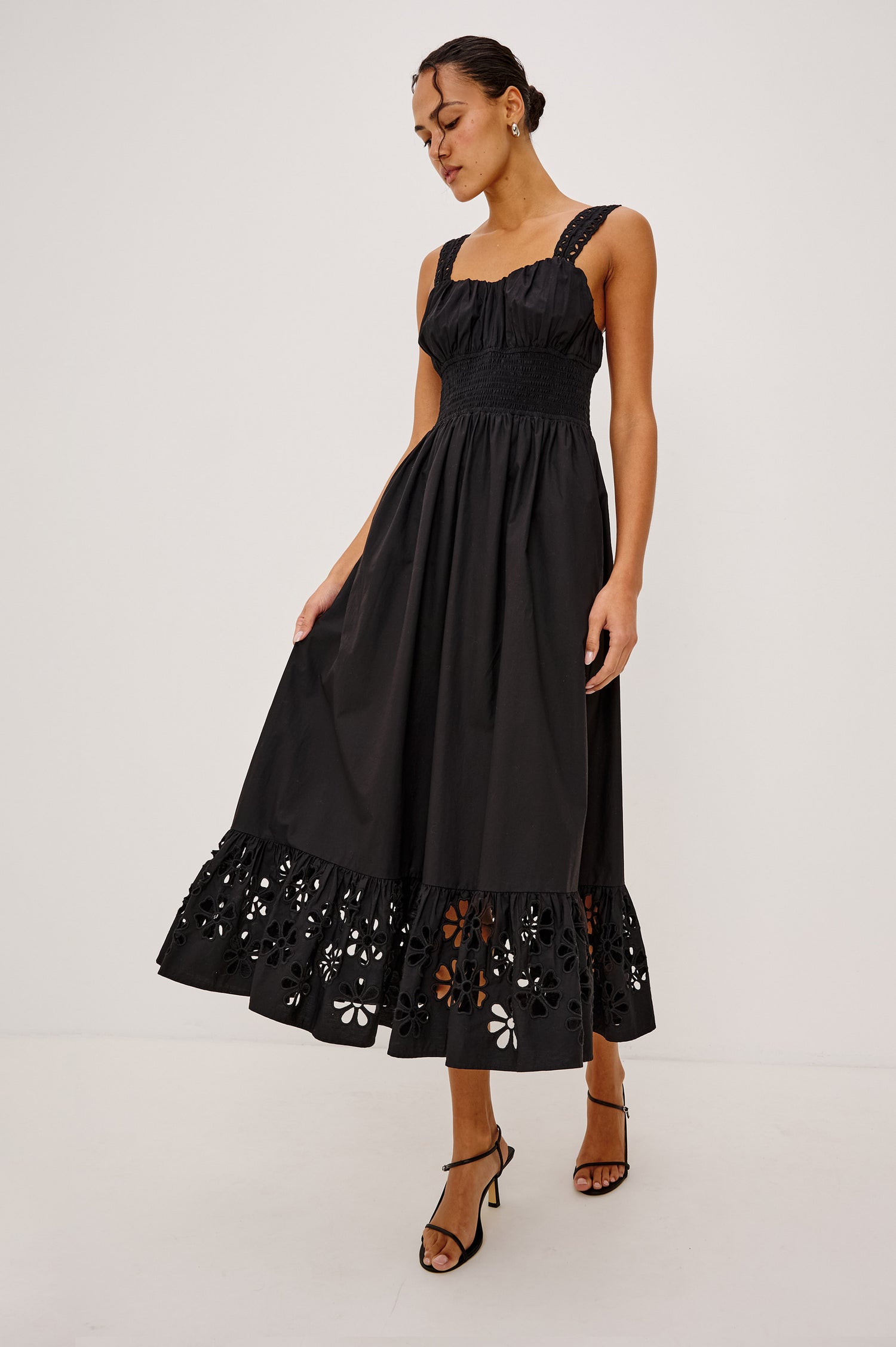Moira Midi Dress in Cotton Poplin With Wide Embroidered Shoulder Straps, Soft Sweetheart Neckline, Smocked Empire Waist, Fully Lined Skirt With Floral Cutwork at Hem in Black Colorway - Full Body Front View Featured on Model