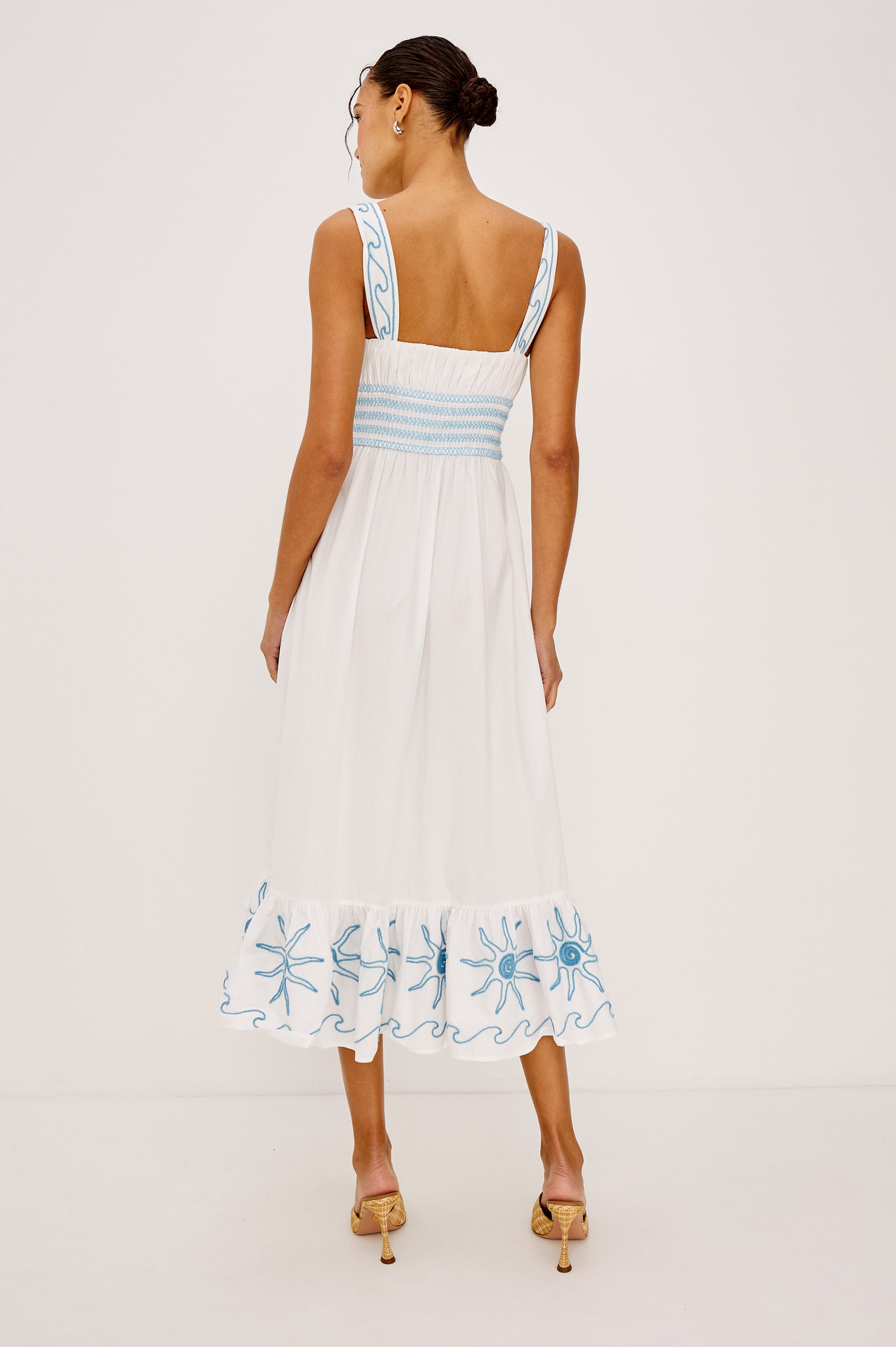 Moira Midi Dress in Cotton Poplin With Wide Embroidered Shoulder Straps Soft Sweetheart Neckline Smocked Empire Waist Fully Lined Skirt With Floral Cutwork at Hem in a White Colorway With Blue Embroidery Details - Full Body Back View Featured on Model