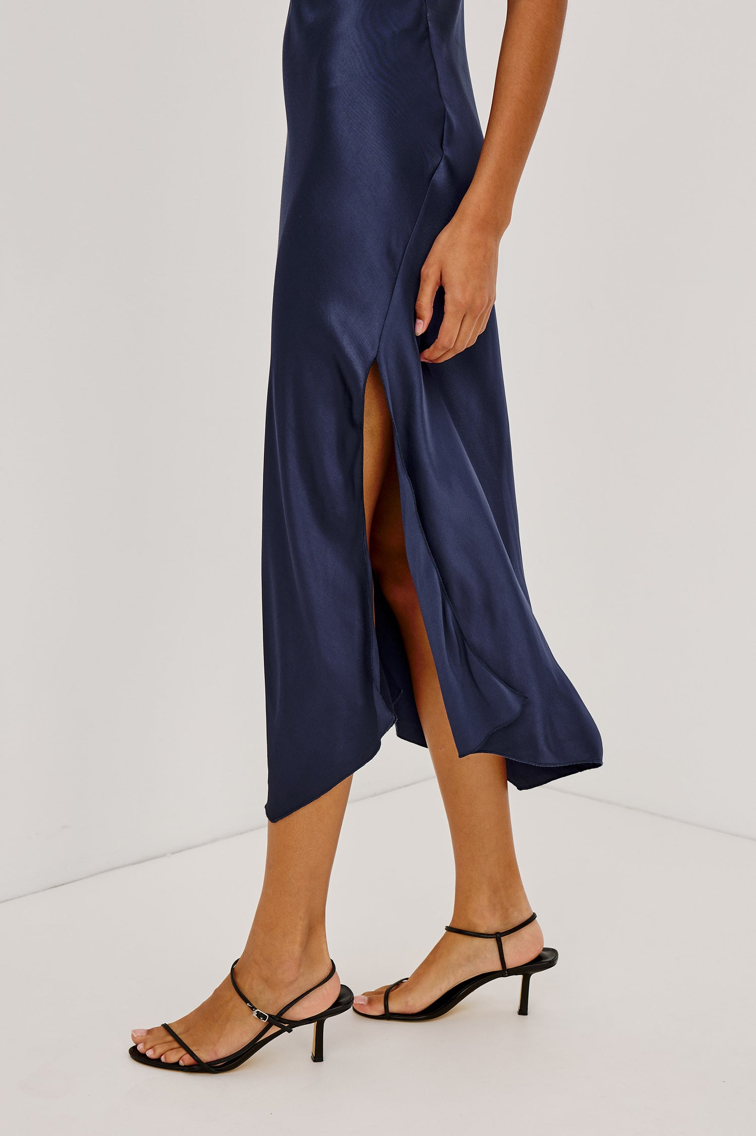 Monique Midi Bias Cut Slip Dress in Satin-Back Crepe With V-Neckline, Asymmetric Hem, and Side Slit in Navy Colorway - Lower Body Close Up View Featured on Model