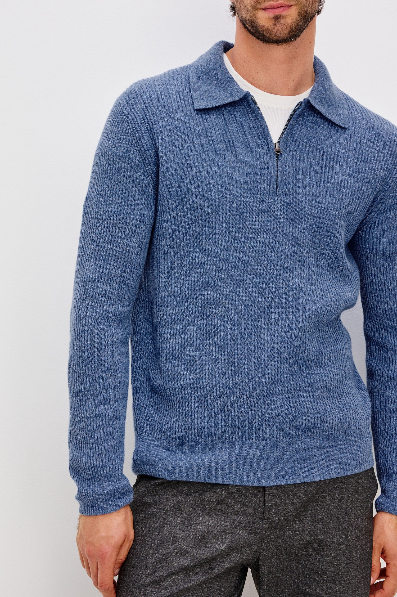 Monty is a collared quarter-zip long sleeved sweater in Cerulean Melange colorway. Front detail view featured on model.