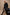 Everest Mid-Thigh Length Coat with Single Button Closure, Notched Lapels and Front Patch Pockets in Black Colorway - Stylized Front Full Body View Featured on Model