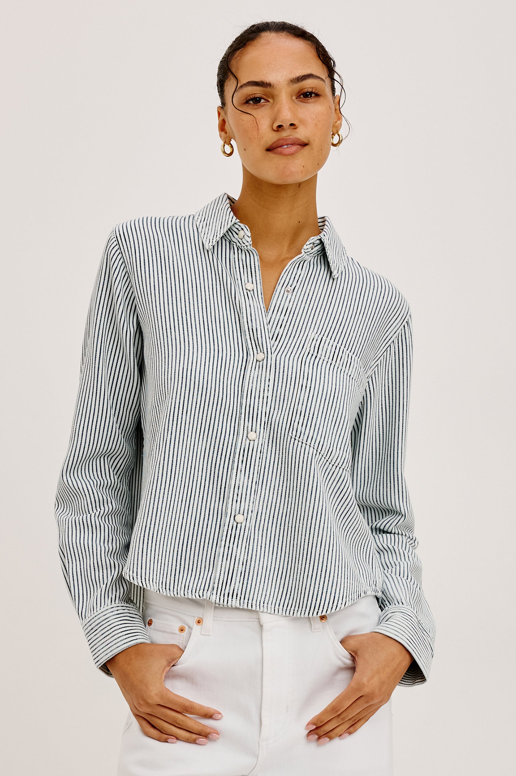 Noa Crop Denim Shirt With Boxy Fit, Front Snap Buttons, a Chest Patch Pocket, and Long Sleeves in Railroad Stripe Colorway - Upper Body Front View Featured on Model