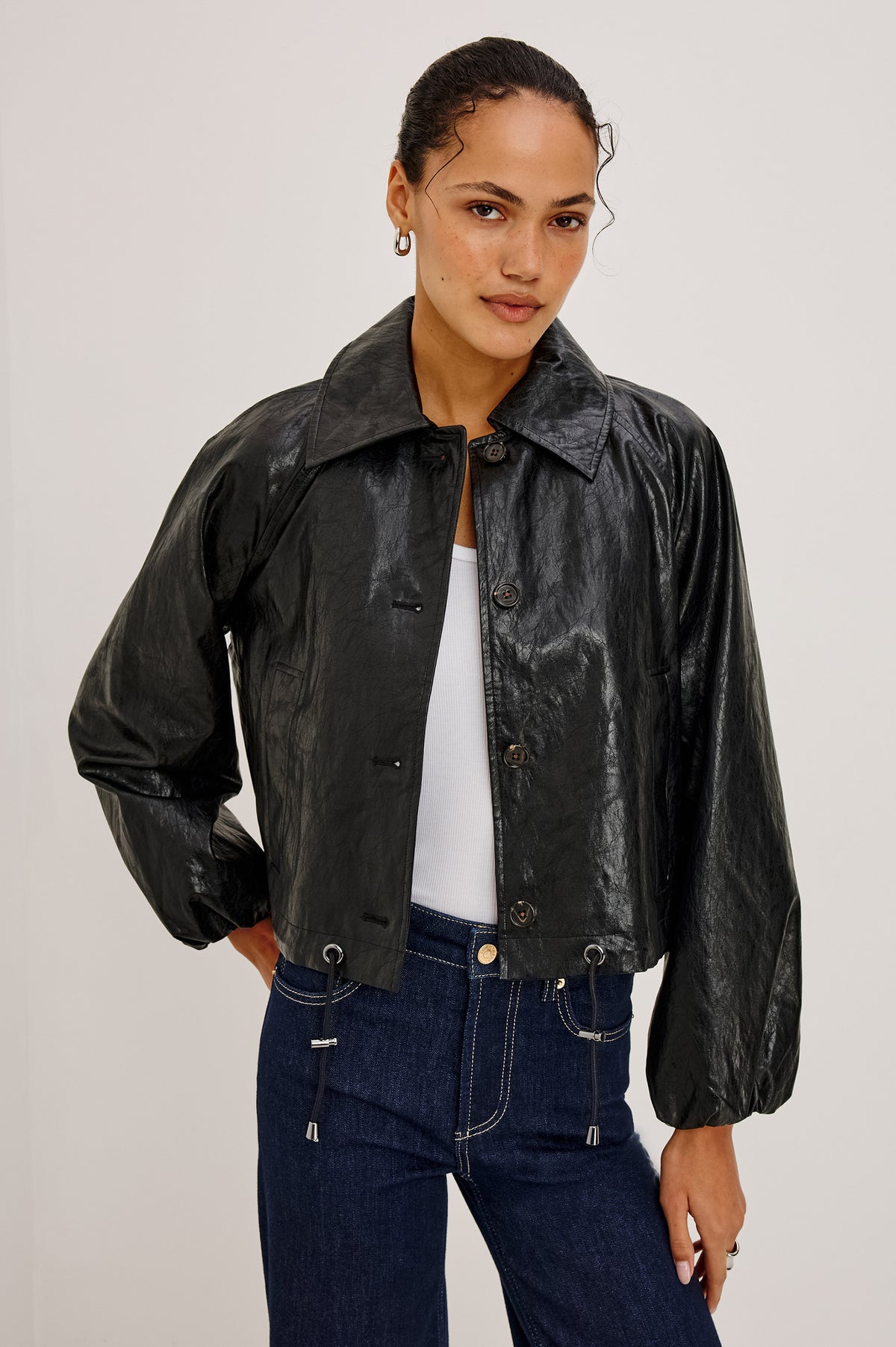 North Jacket in Vegan Leather With Cropped, Boxy Fit, Drawcord Hem, Oversized Collar, Front Buttons, and Welt Pockets in Black Colorway - Upper Body Front View Featured on Model.