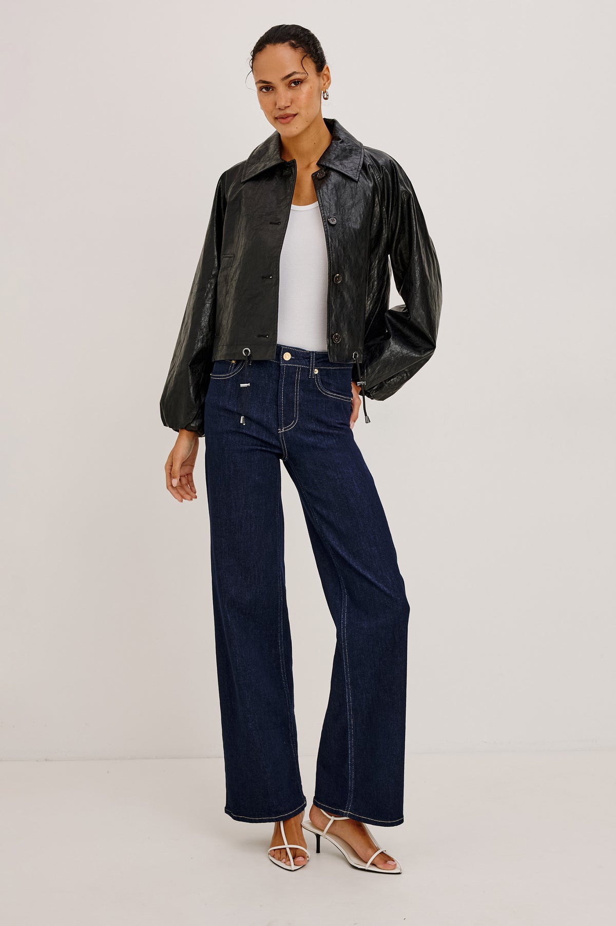 North Jacket in Vegan Leather With Cropped, Boxy Fit, Drawcord Hem, Oversized Collar, Front Buttons, and Welt Pockets in Black Colorway - Full Body Front View Featured on Model.