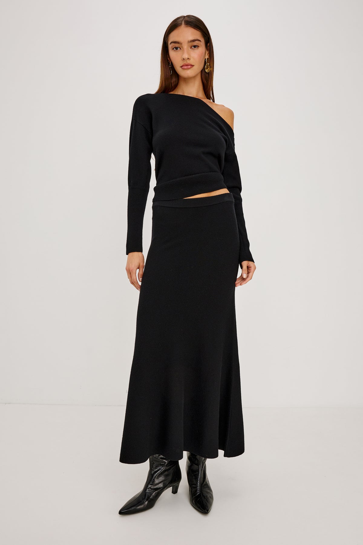 Odita Maxi Skirt in Soft Ribbed Wool Blend Knit With Elastic Waist, and A-Line Silhouette in Black Colorway - Front Full Body View Featured on Model.