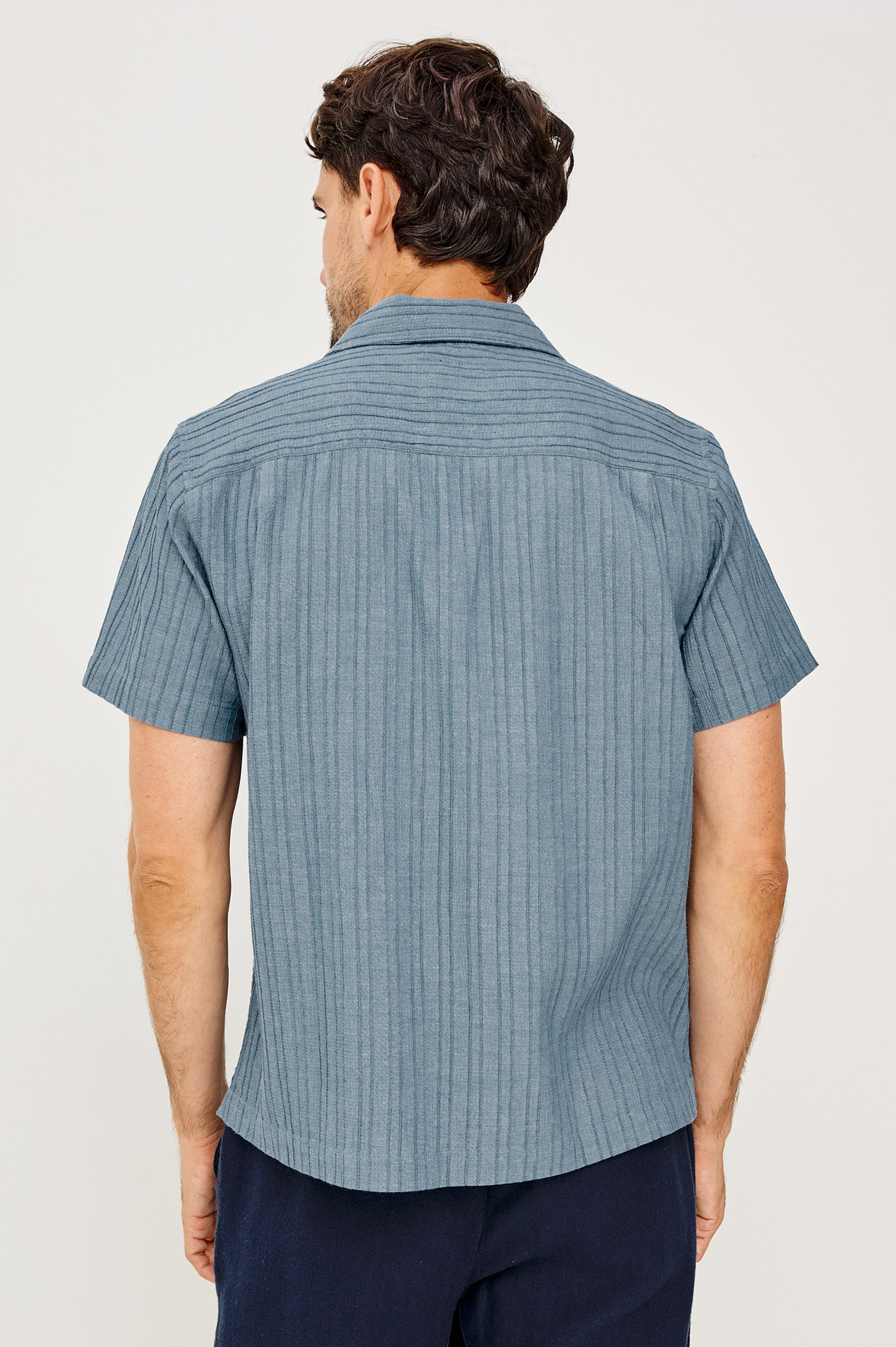 Ohana Button-Up Shirt in Textured Shirting WIth Short Sleeves, Collar, and Relaxed Fit in Marine Colorway - Upper Body Back View Featured on Model