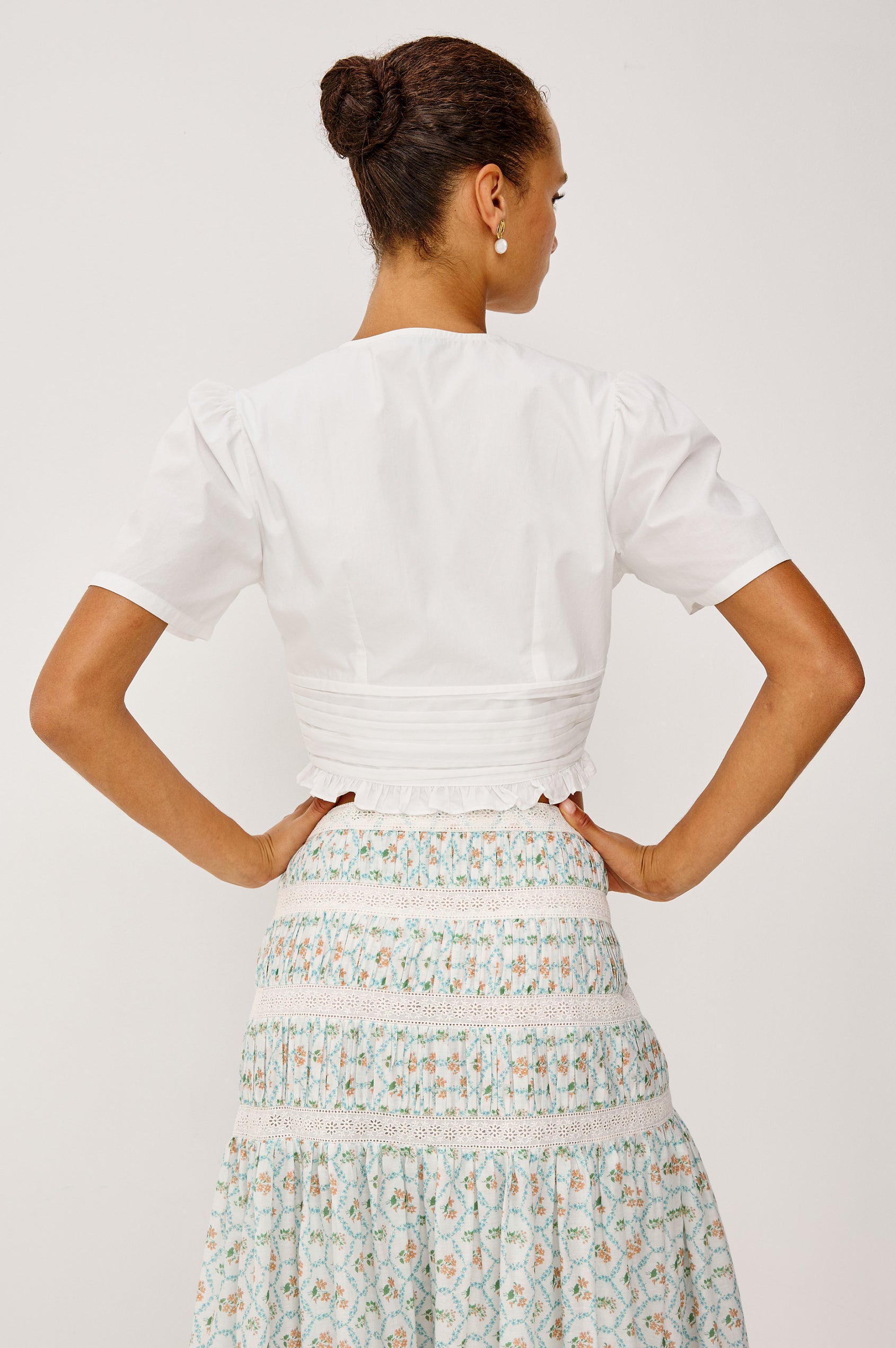 Olympia Super Croped Top in Cotton Poplin With Wide Cap Sleeves, Shirred Waist Panel, Front Hook-and-Eye Closures, V-Neckline, Wide Cap Sleeves, and is Fully Lined in White Colorway - Upper Body Back View Featured on Model