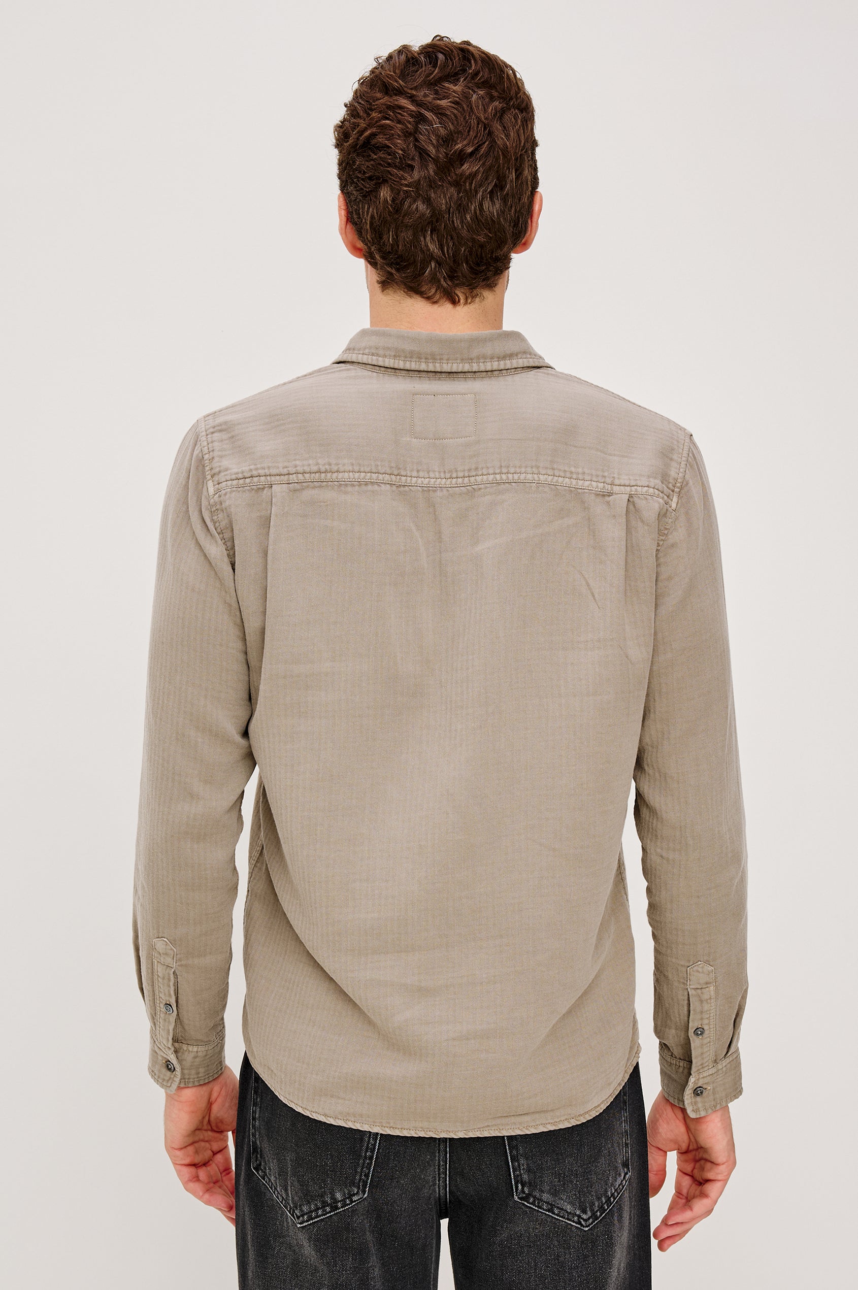 Owens is a long sleeve, collared, button front shirt lightweight cotton, long sleeve, and features a subtle pattern variation on the backside of the fabric in Desert Path colorway. Back view featured on model.