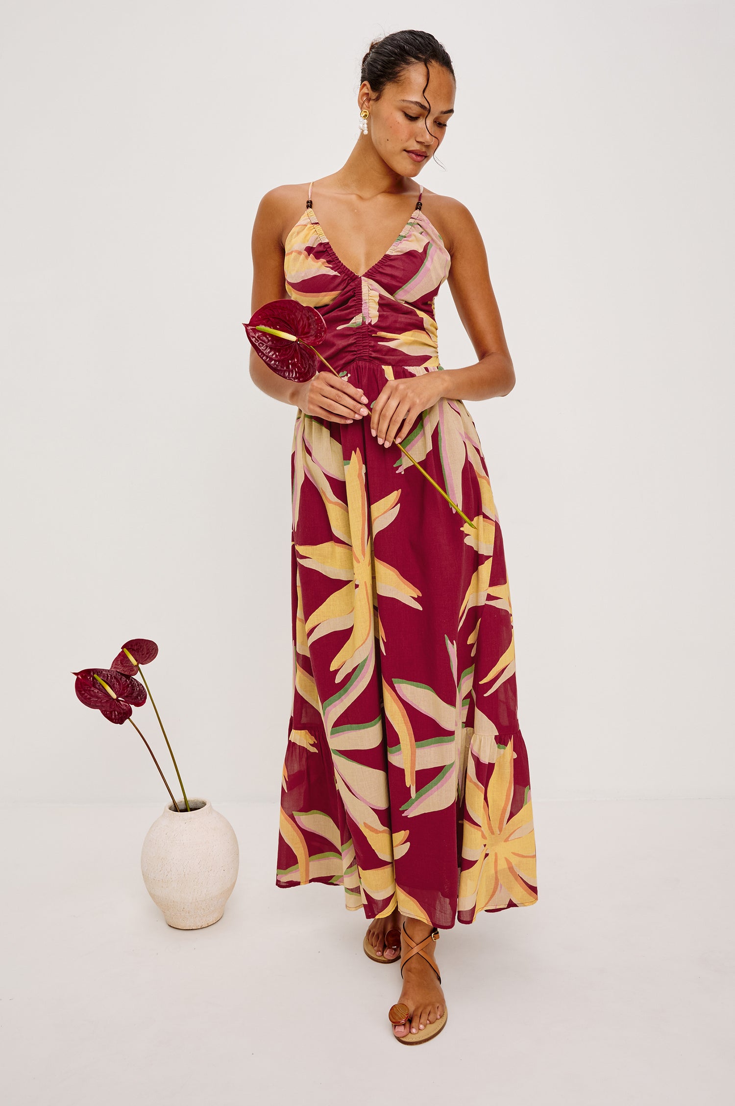 Palm Maxi Dress in Beach Cotton WIth Fitted Shirred Bodice V-Neckline Adjustable Shoulder Straps With Wooden Bead Detailing and Tiered Skirt in Red Palma Colorway - Full Body Front View Featured on Model