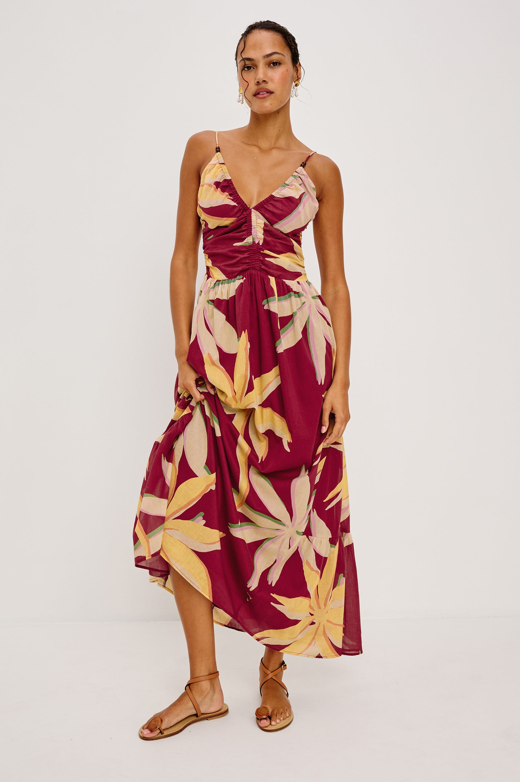 Palm Maxi Dress in Beach Cotton WIth Fitted Shirred Bodice V-Neckline Adjustable Shoulder Straps With Wooden Bead Detailing and Tiered Skirt in Red Palma Colorway - Full Body Front View Featured on Model