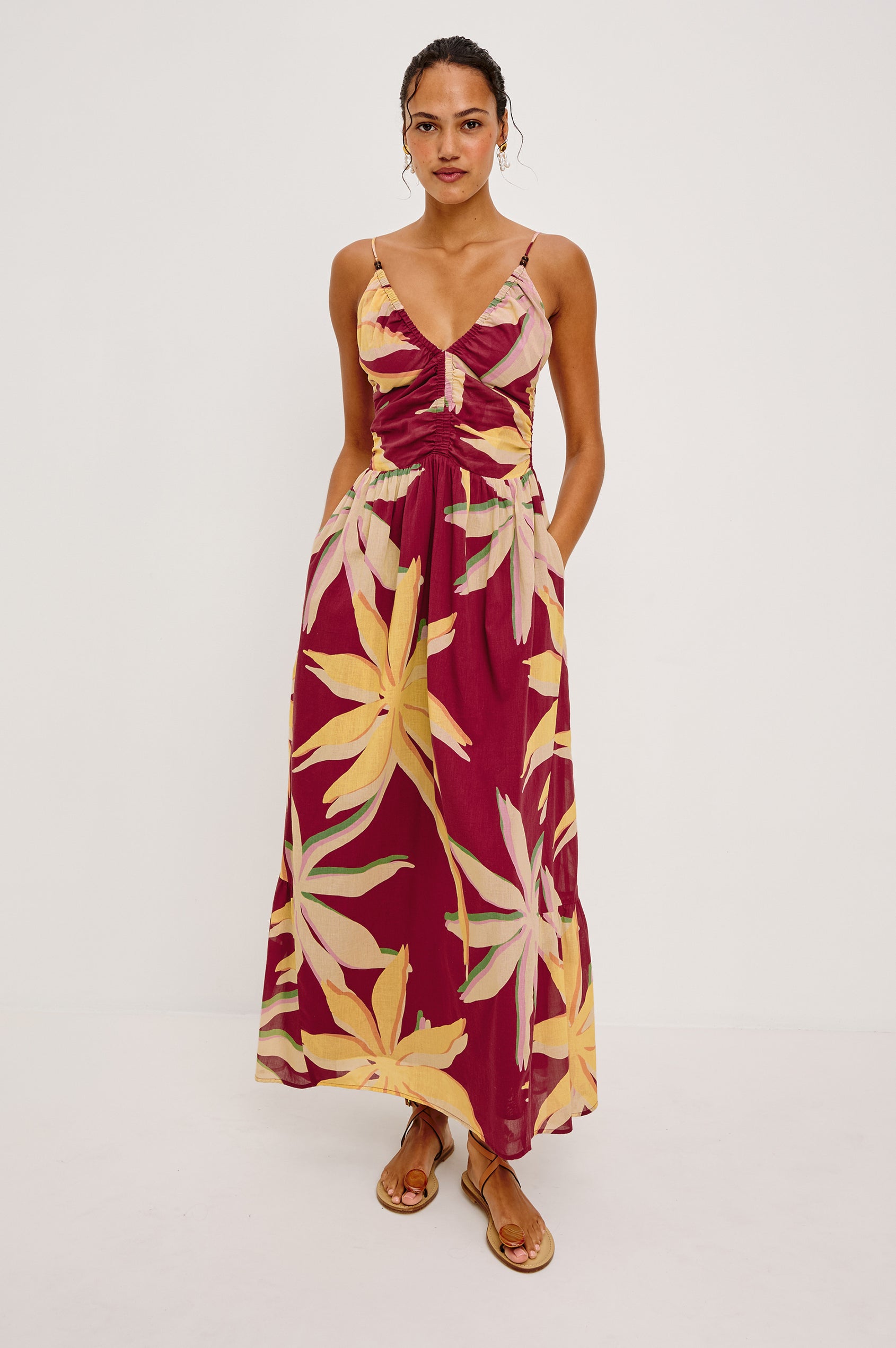 Palm Maxi Dress in Beach Cotton WIth Fitted Shirred Bodice V-Neckline Adjustable Shoulder Straps With Wooden Bead Detailing and Tiered Skirt in Red Palma Colorway - Full Body Front View Featured on Model
