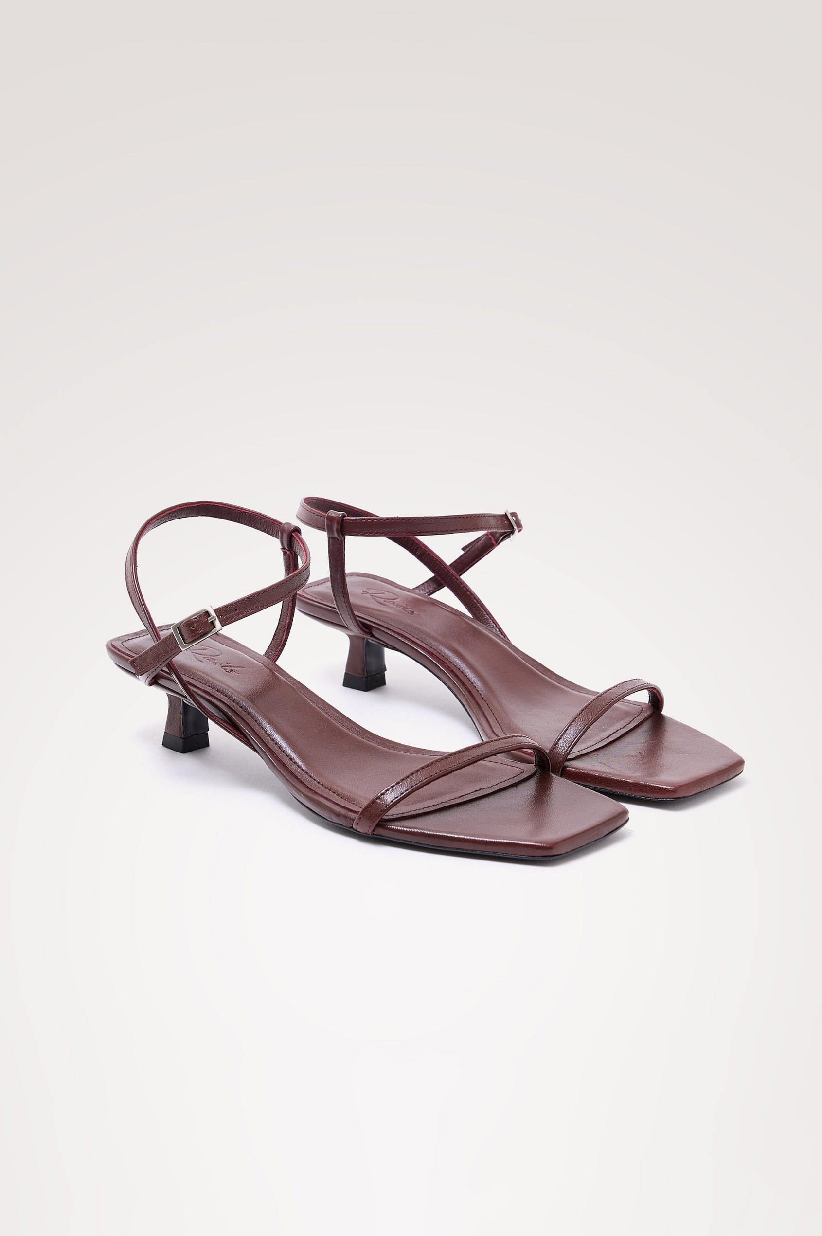 Palma Sandal Heel in Top-Grain Leather With Single Toe Strap, Adjustable Buckled Wrap Ankle Strap, and Low Heel in Burgundy Colorway - angeled frontview of shoe.
