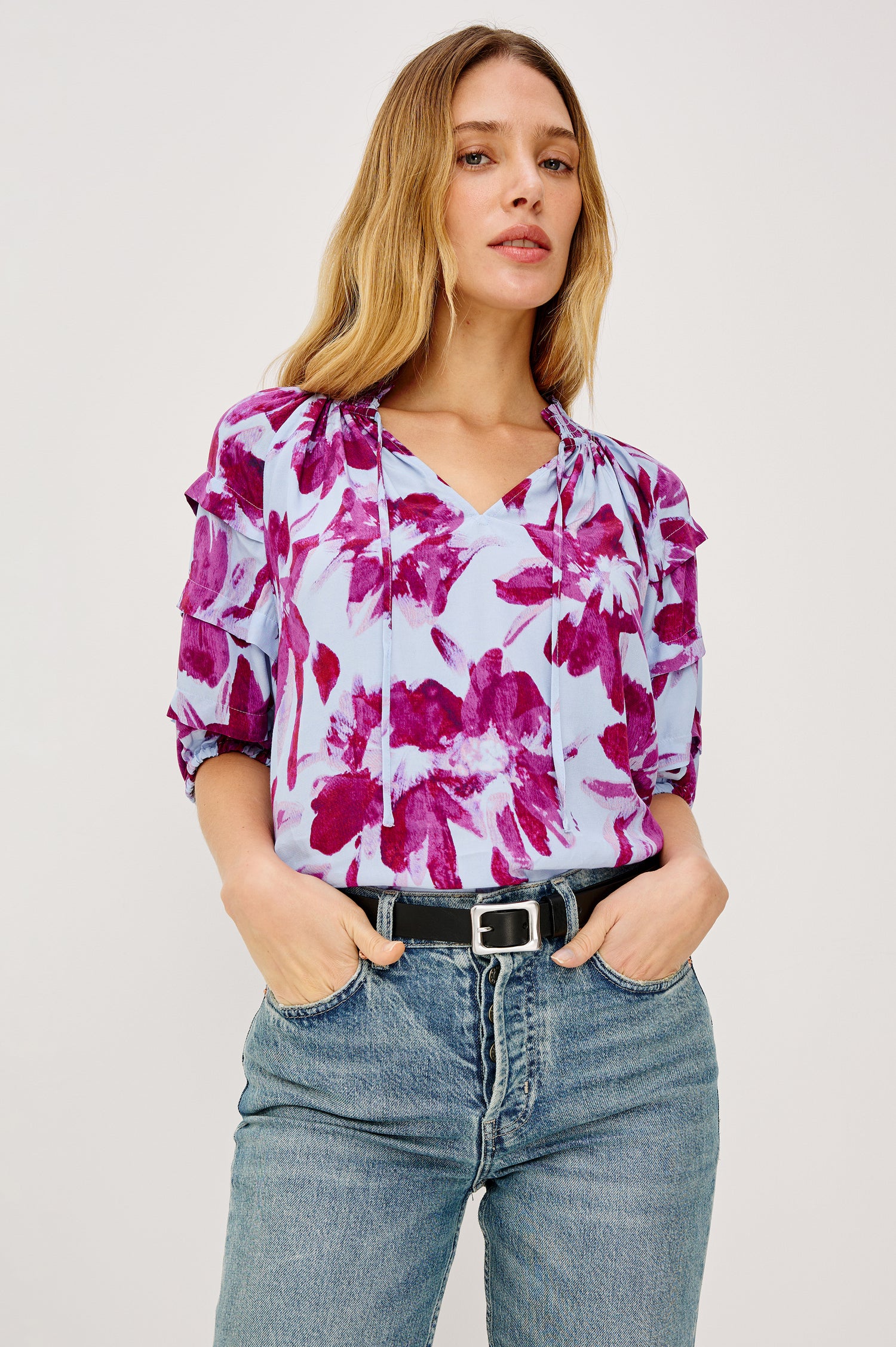 Paris Short-Sleeve Top with Shirred Collar, V-neckline with Ties, Deep Pleats on Sleeves and Elastic at the Sleeve Opening in Blue Lily Colorway, Blues and Pink- Front Tucked View Featured on Model