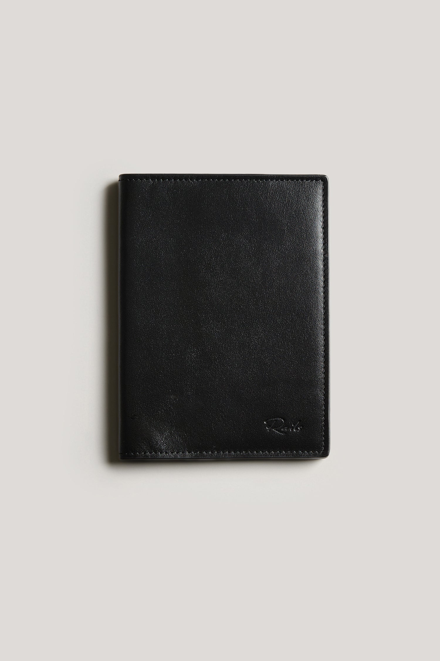 Leather passport holder folded, front view, in Black colorway.