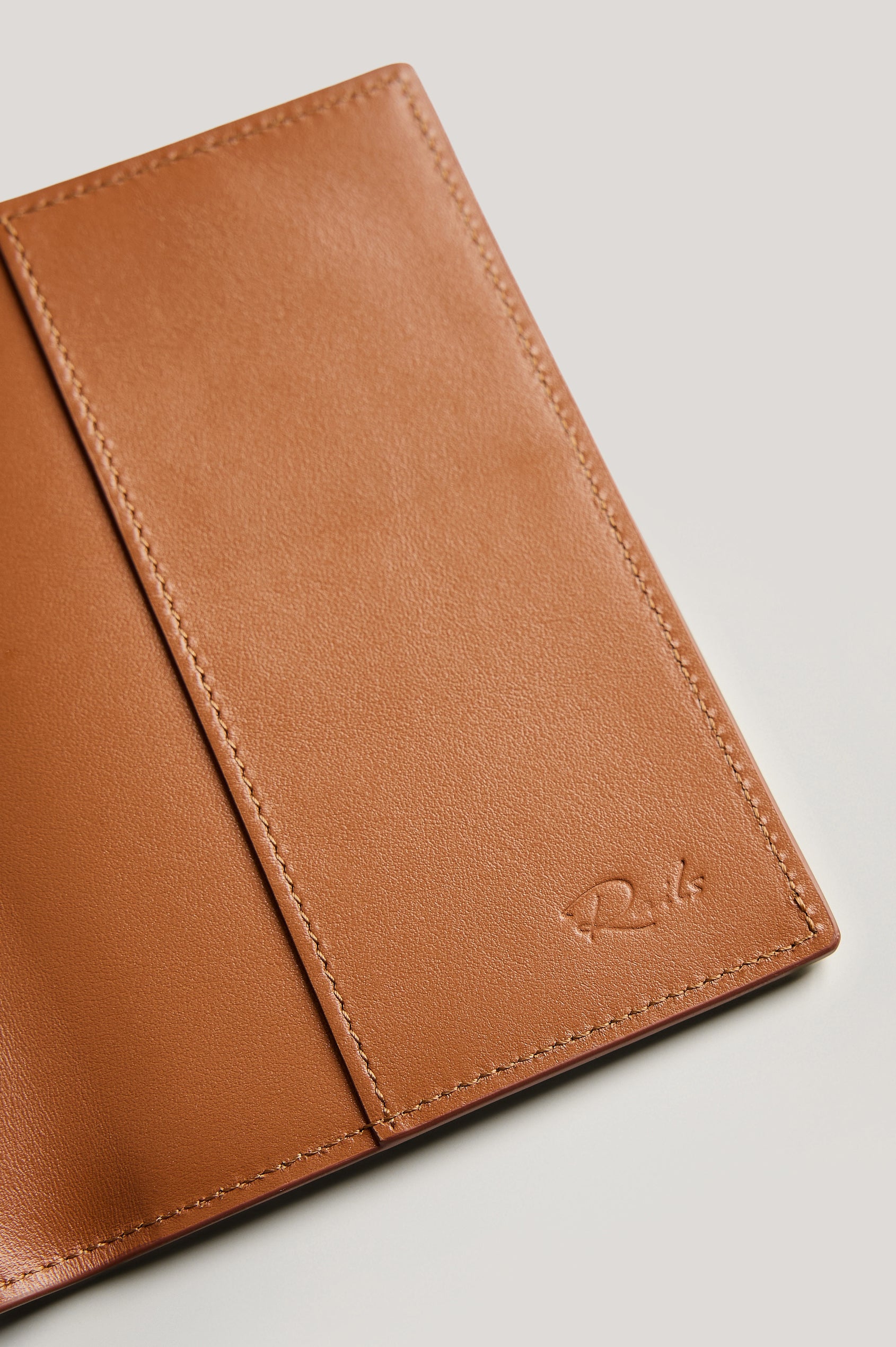 Leather passport holder opened, close up inside view, in brown Cognac colorway.
