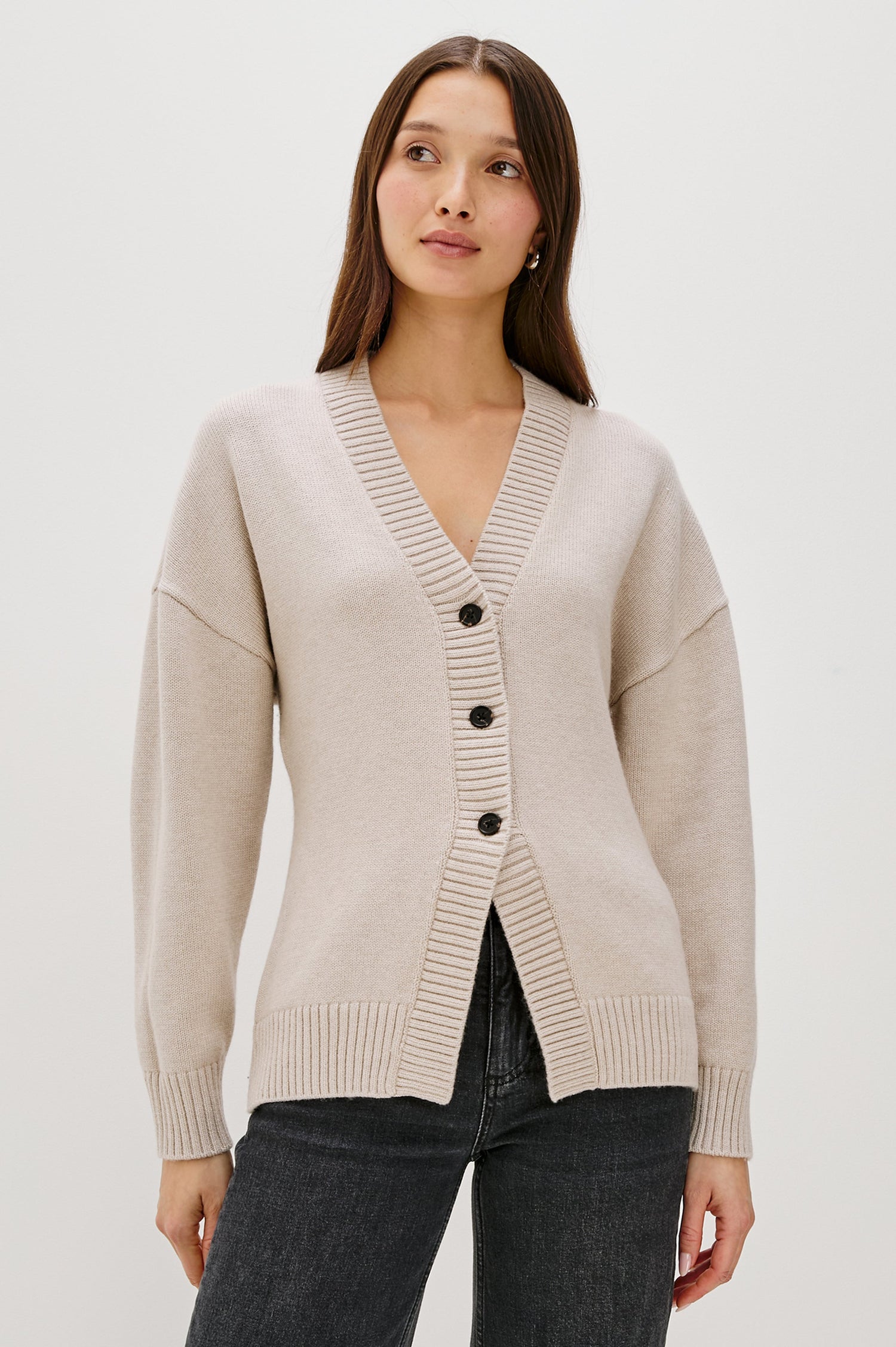 Longline cardigan in a cotton-wool blend in Taupe Colorway. The design features drop shoulders and a front cutaway detail, creating a soft, relaxed, and flattering silhouette. Front View on Model.