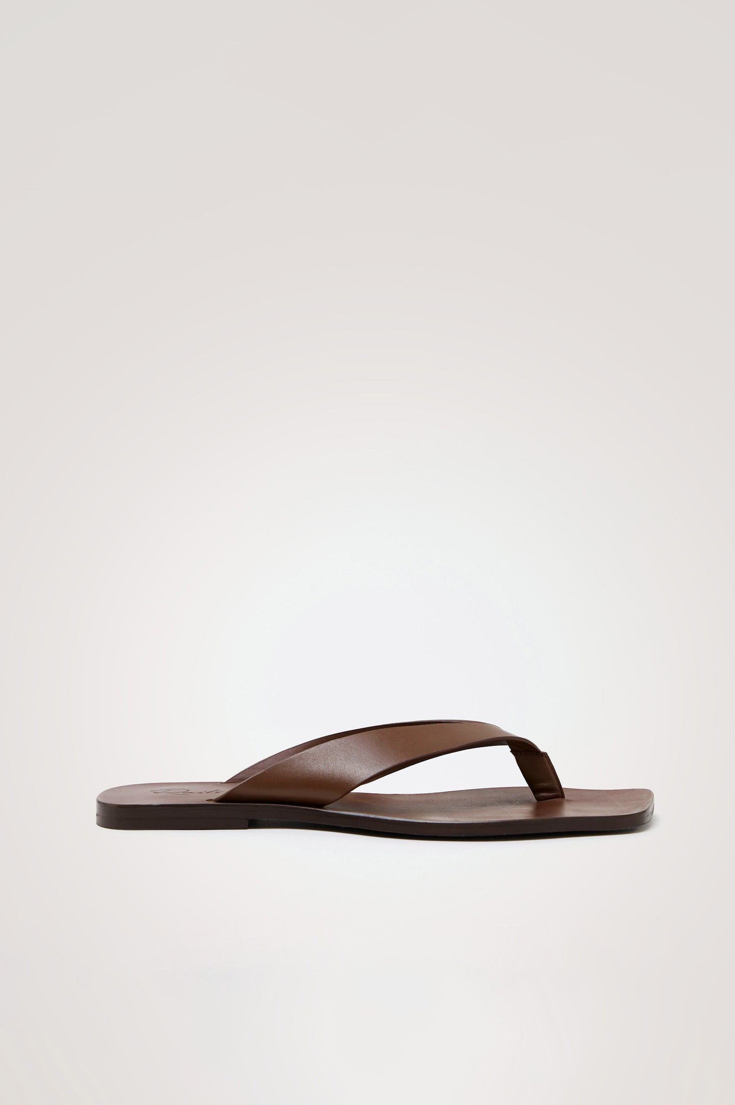 Porto Thong Sandal in Leather With Square Toe and Cushioned Footbed With Branded Embossed Detail in Dark Brown Colorway - Side View Featured