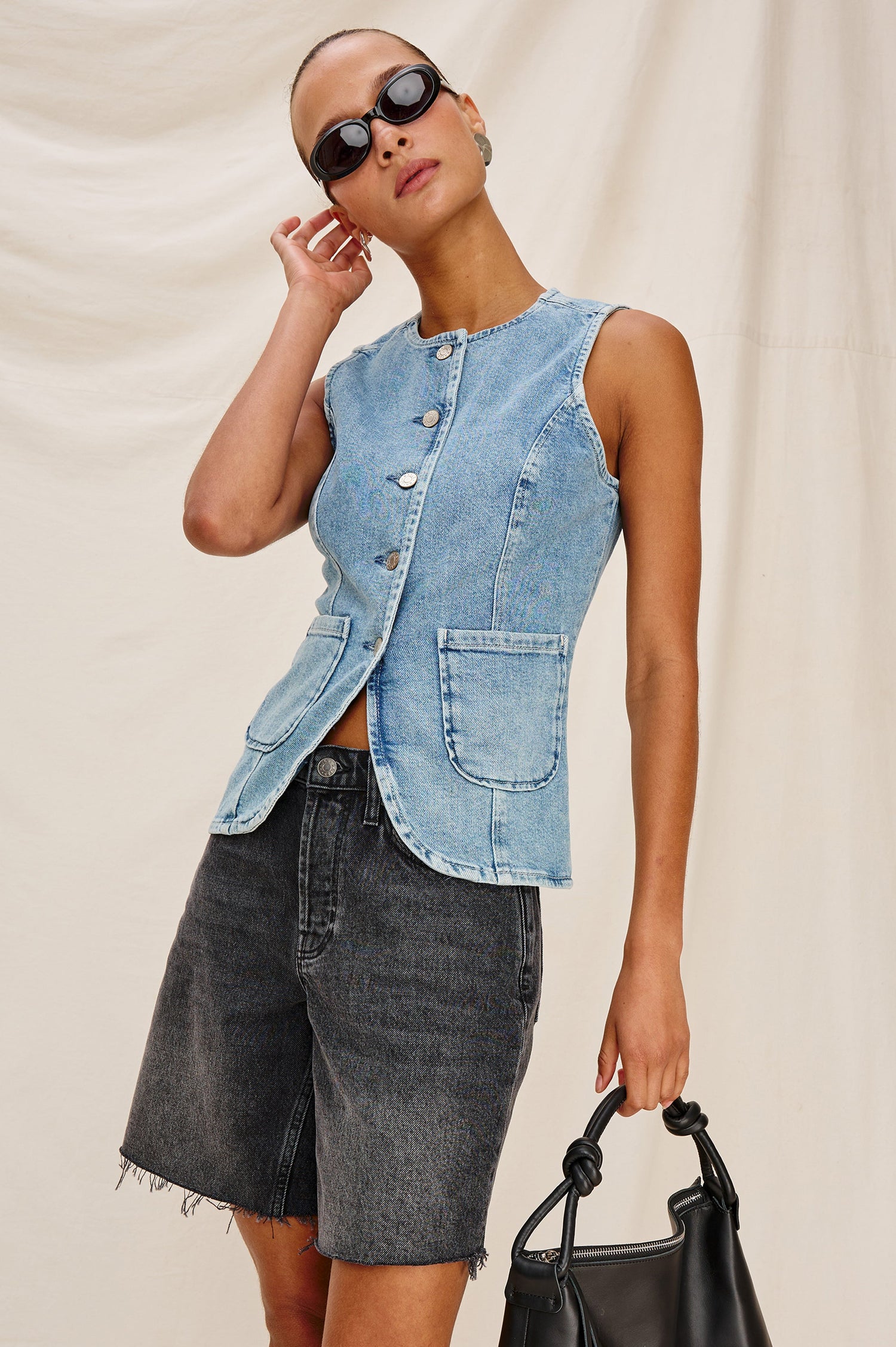 Portola Sleeveless Denim Vest with Exposed Button Front Closure, Crew Neck, Front Patch Pockets and a Scalloped Split Hem in Blue Eyed Girl Colorway. Full Body Front View Shown on Model.