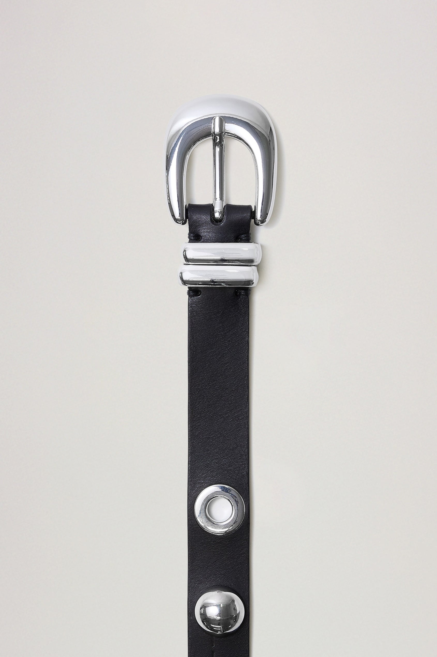 Presley is a sleek, refined belt designed in supple leather, with subtle statement-making details, including studs and grommets. Flat view of belt featured off model.