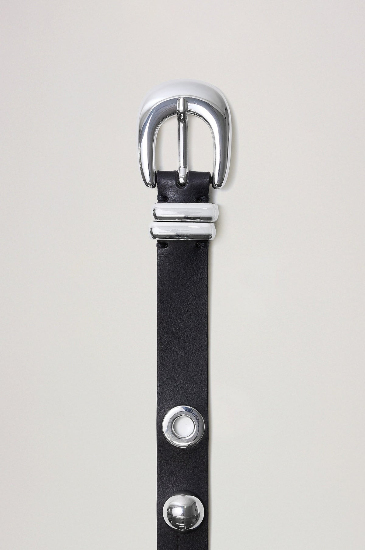 Presley is a sleek, refined belt designed in supple leather, with subtle statement-making details, including studs and grommets. Flat view of belt featured off model.