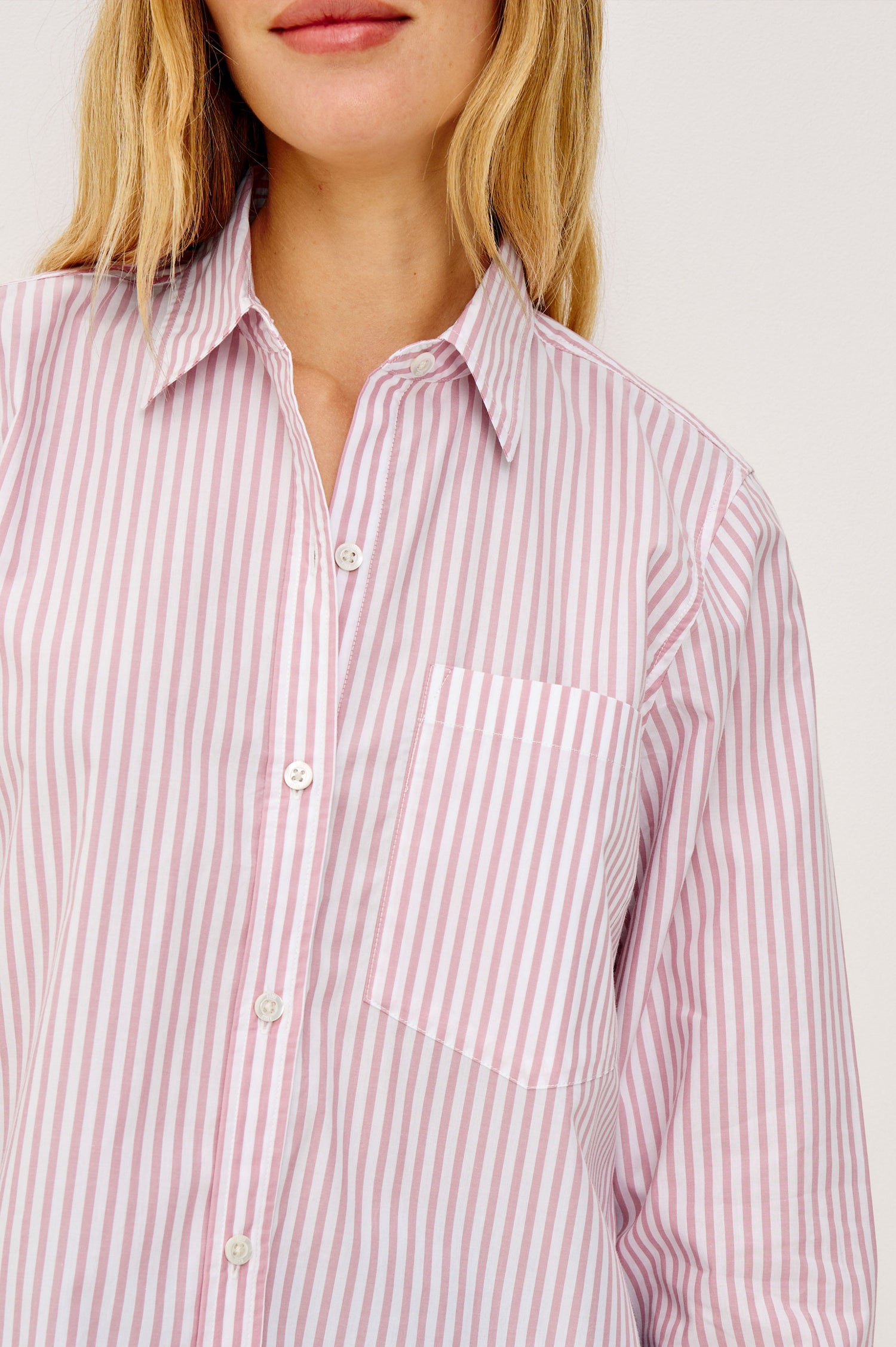 Ramy Cropped Button-Up Shirt in Cotton Poplin With Collar, Front Buttons, and Long Sleeves in Rose Stripe Colorway - Upper Body Front View Featured on Model