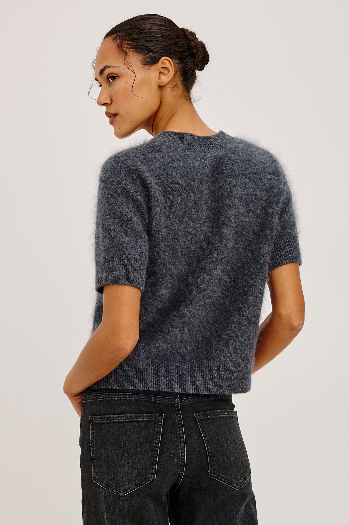 Roman Cardigan Sweater in Brushed Wool With Fluffy Feel With Slightly Cropped Fit, Crew Neck, Self-Covered Front Buttons, Short Sleeves, and Ribbed Trim in Charcoal Colorway - Upper Body Back View Featured on Model