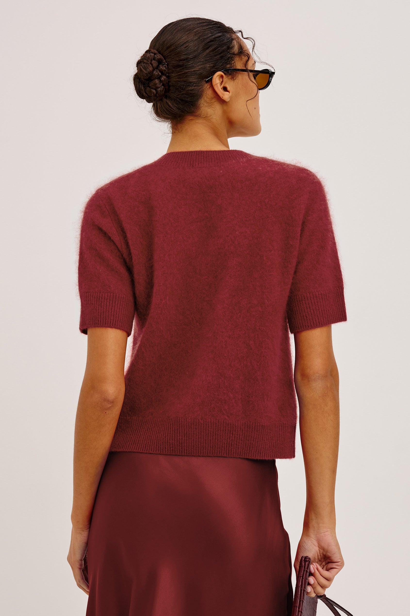 Roman Cardigan Sweater in Brushed Wool With Fluffy Feel With Slightly Cropped Fit, Crew Neck, Self-Covered Front Buttons, Short Sleeves, and Ribbed Trim in Crimson Colorway - Upper Body Back View Featured on Model