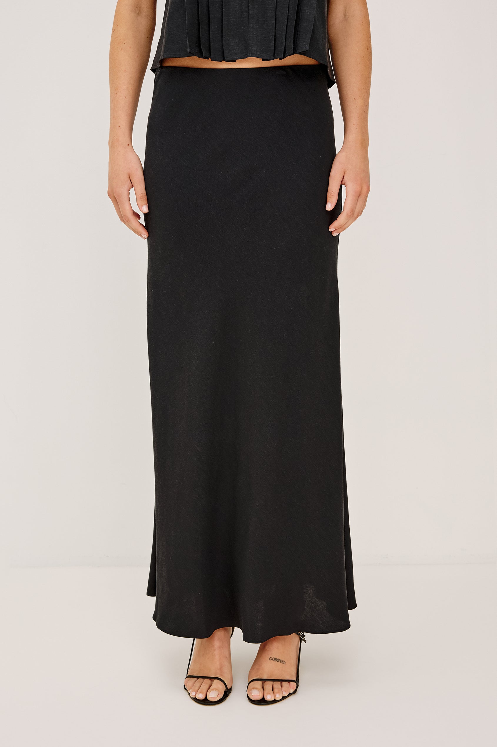 Romina Maxi Skirt in Luxe Linen With High-Waisted Fit and Elastic Waistband in Black Linen Colorway - Lower Body Front View Featured on Model