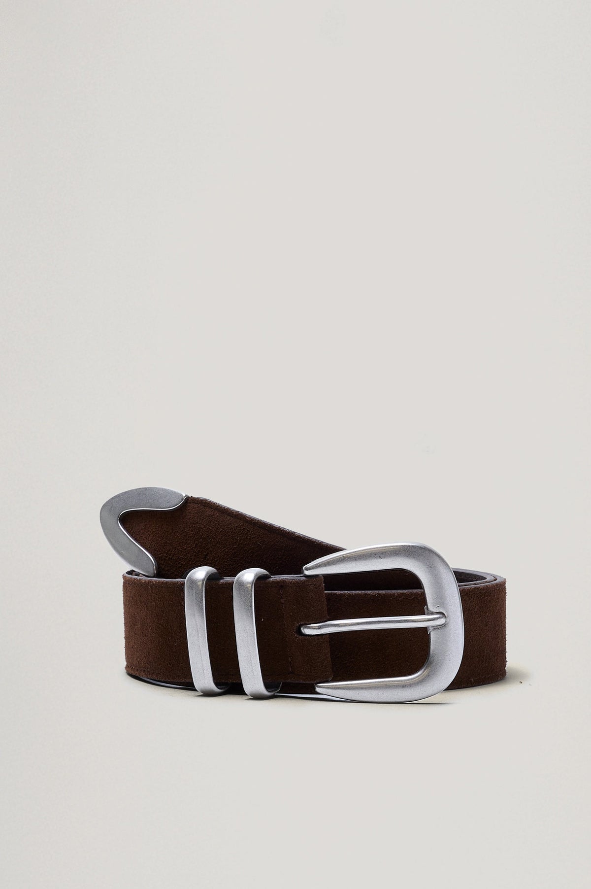 Ryder suede leather belt features silver metal hardware, a metal tip in Chocolate colorway, coiled front view featured 