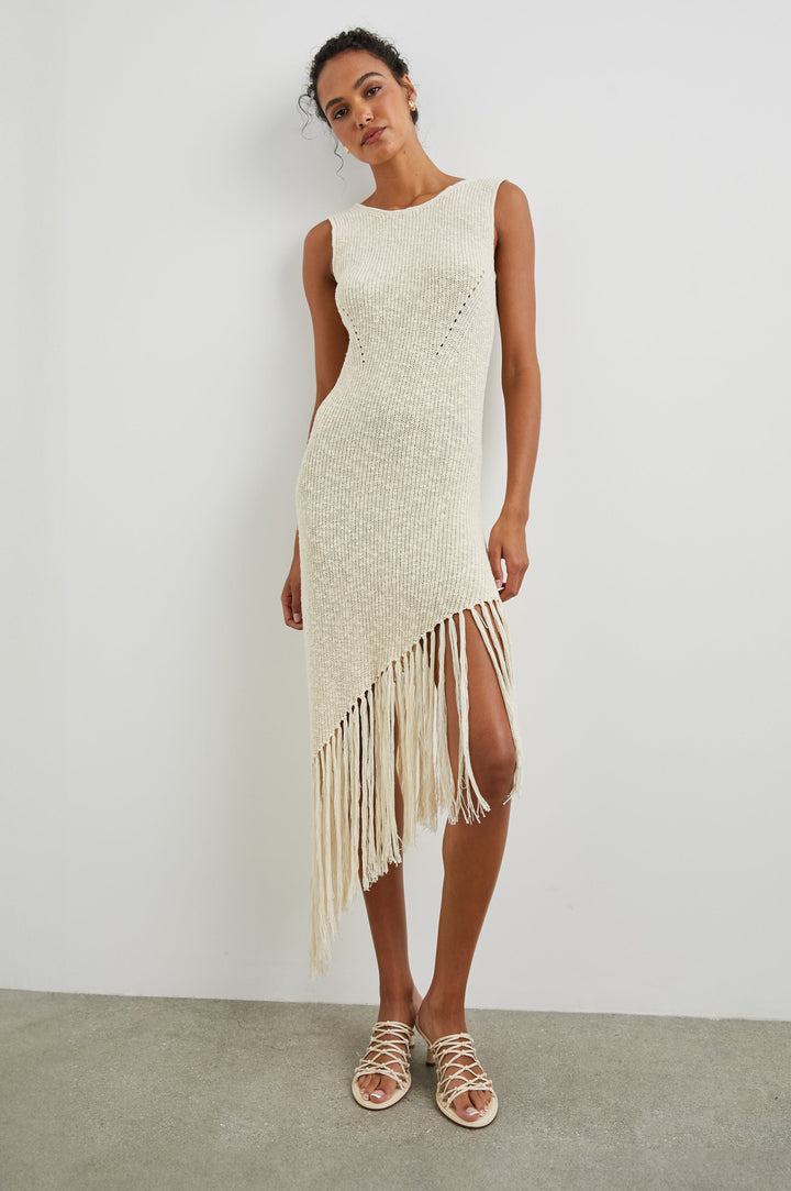 Rylee Sleeveless Ribbed Dress with a Scoop Neck, and a Fringed Asymmetrical Hemline from the Upper Thigh to the Knee in Ecru Colorway - Front Full Body View Featured on Model