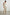 Rylee Sleeveless Ribbed Dress with a Scoop Neck, and a Fringed Asymmetrical Hemline from the Upper Thigh to the Knee in Ecru Colorway - Front Full Body View Featured on Model