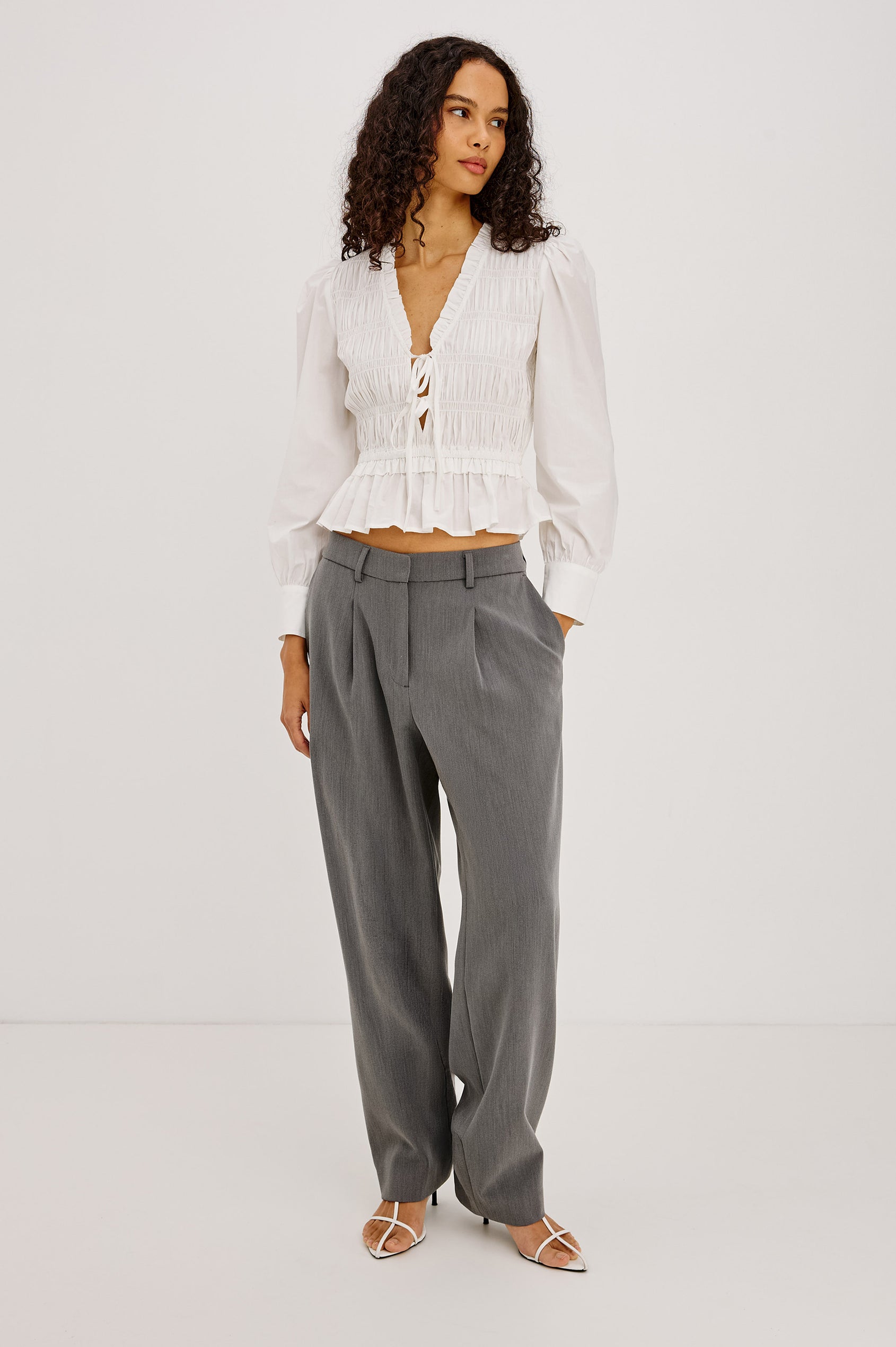 Sami Shirt in Cotton Poplin With V-Neckline Front Ties, Shirred Fitted Bodice, Flared Hem, Ruffle Trim, and Long Puff Sleeves With Buttoned Cuffs in White Colorway - Full Body Front View Featured on Model