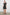 Samina Above-Knee Sleeveless Dress with drawstrings at the Arm Openings, Buttons along the Bodice, A Cinched Waist and a Tiered Skirt in Ash Leno Stripe Colorway, with Grey vertical stripes on black - Front Full Body View Featured on Model 