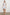 Samina Above-Knee Sleeveless Dress with drawstrings at the Sleeve Openings, Buttons along the Bodice, A Cinched Waist and a Tiered Skirt in Sonoma Stripe Colorway, Thin Vertical Blue Stripes on White - Front Full Body View Featured on Model 