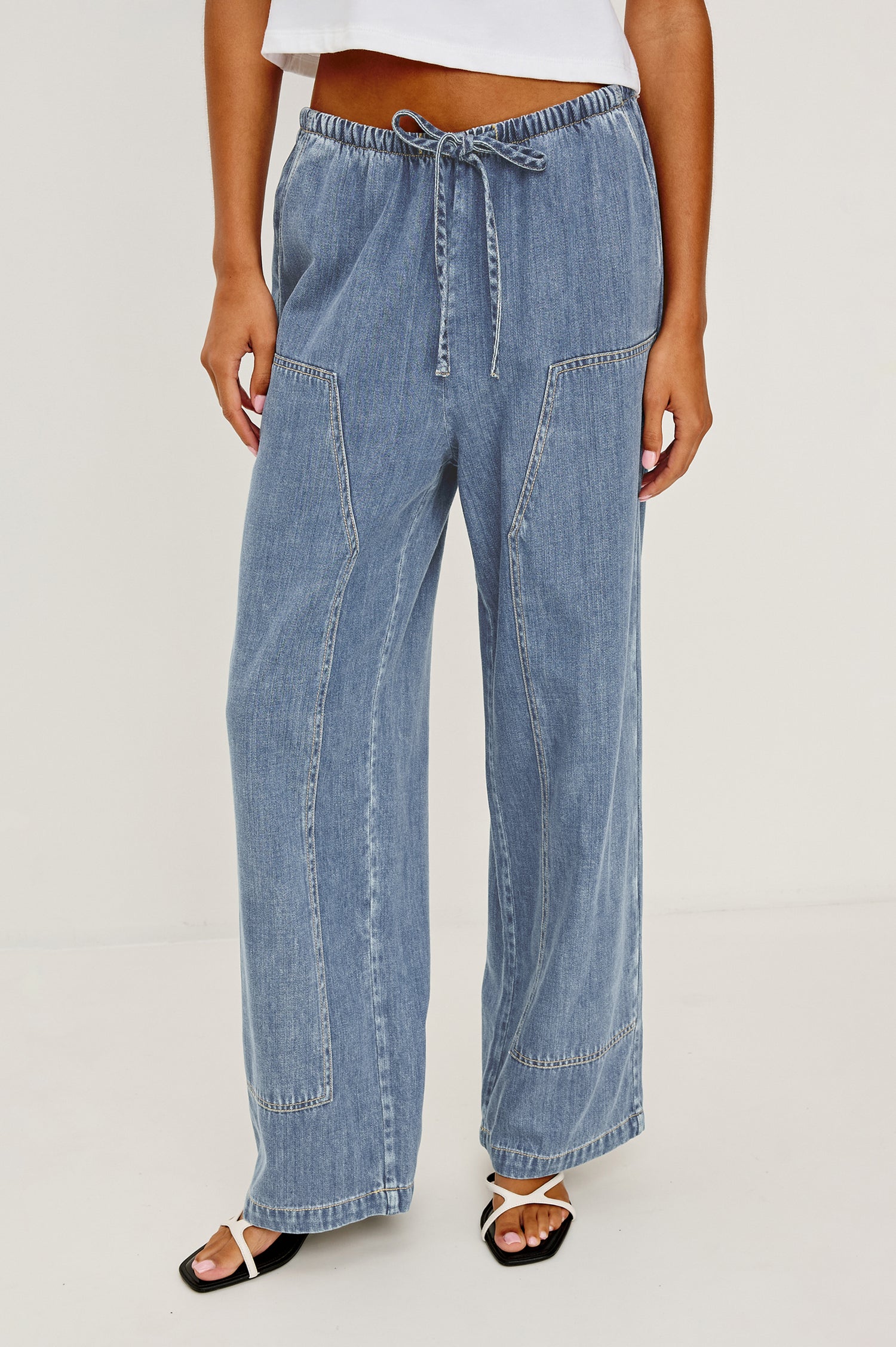 Sanderson Pant in Cotton Lyocell Denim With Relaxed Fit, Drawstring Waist Tie, Side Pockets, and Carpenter-Style Leg Panels in Antique Blue Colorway - Lower Body Front View Featured on Model