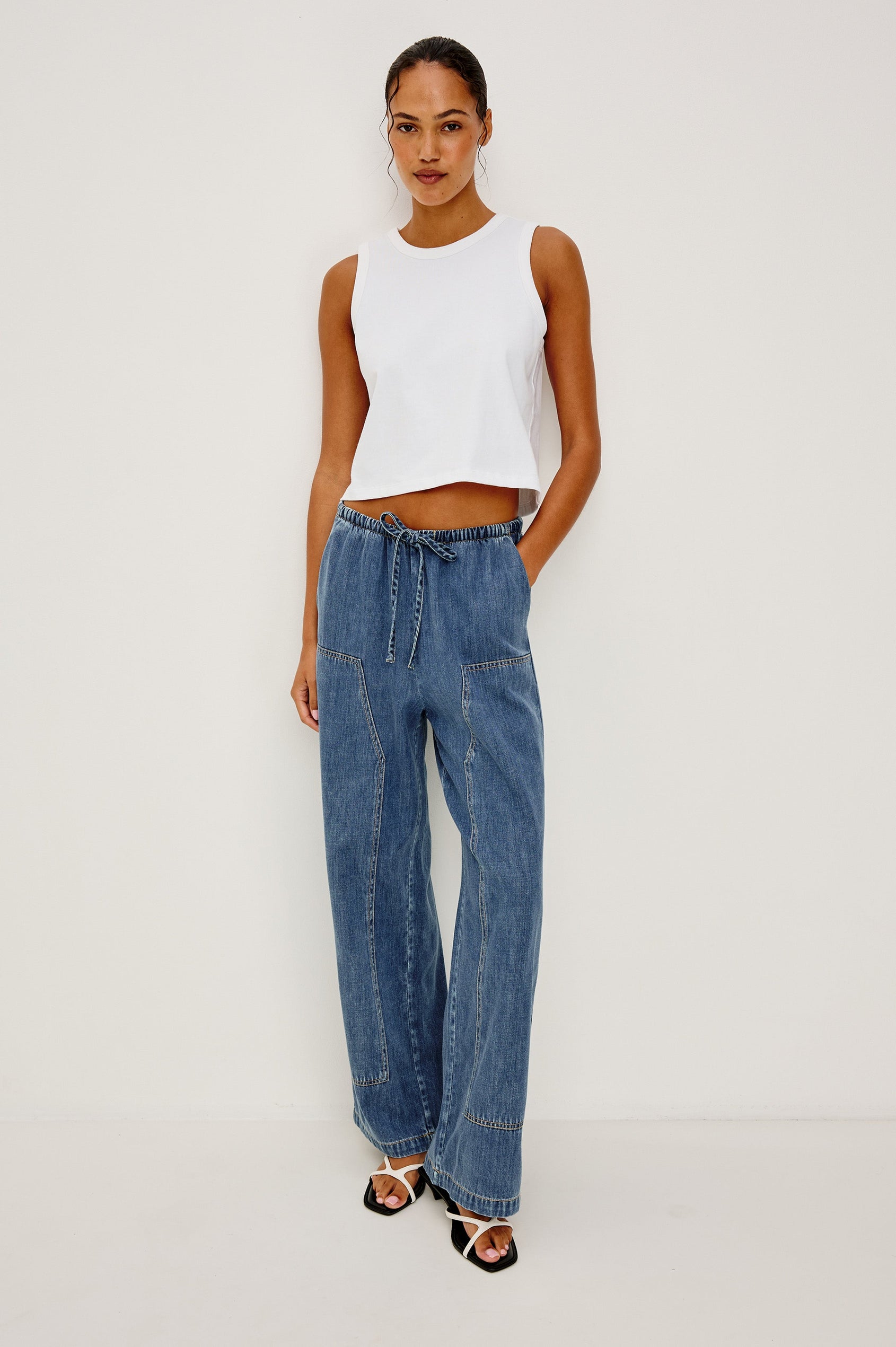 The Sanderson is a wide leg pull on pant with an encased drawstring waist tie, it has workwear inspired contrast topstitching on the front leg panels. Full Body Front view featured on model.