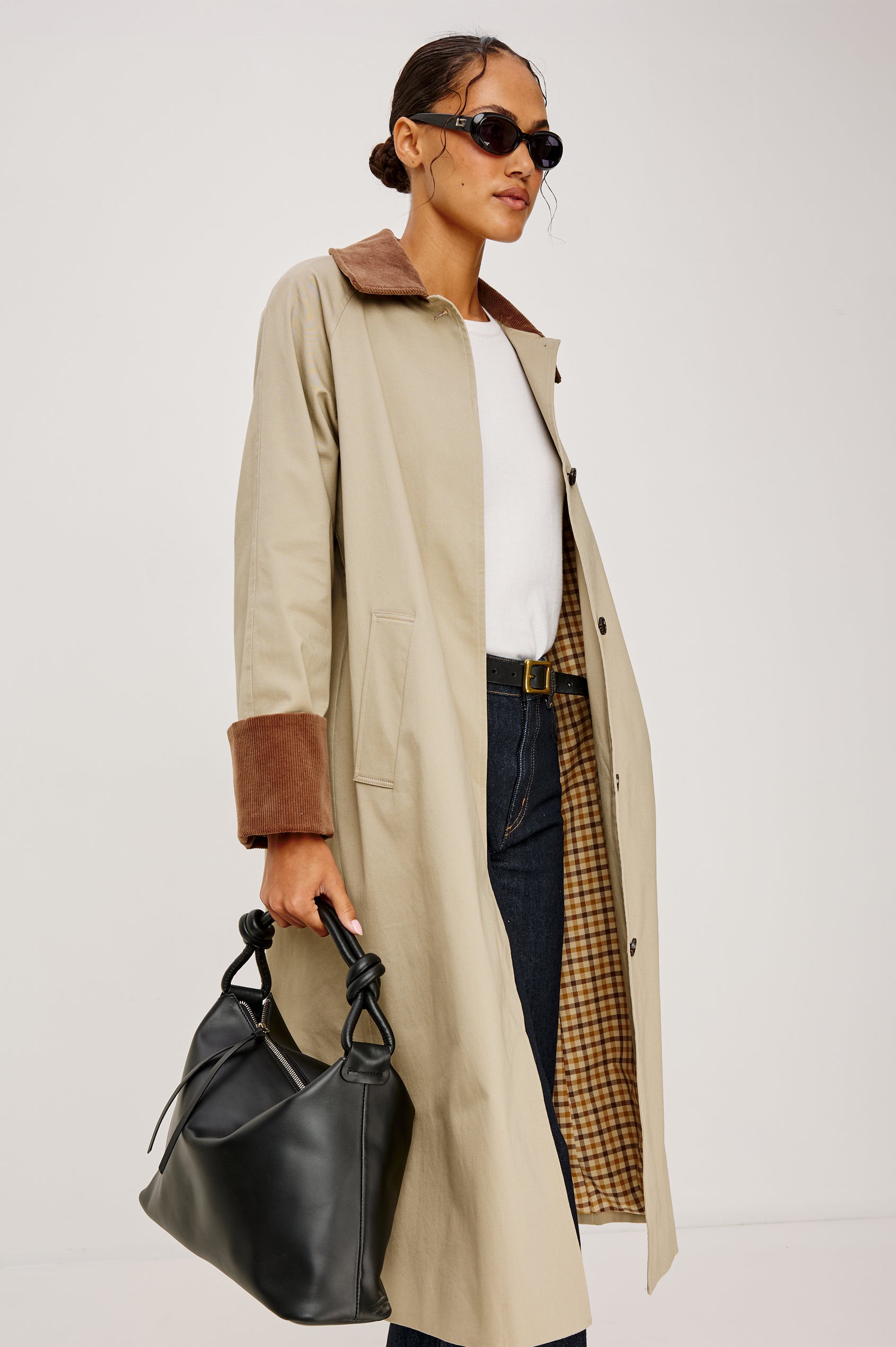 The Siena is a true slouchy hobo bag, crafted from smooth leather with a knotted top strap and a zip closure finished with a fringed tassel. In Black Leather Colorway. Full body side view featured on model.