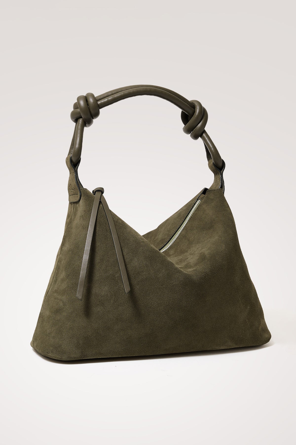 Siena Hobo Bag in Suede With Knotted Top Strap, Zip Closure With Fringe Tassel Pull, Microsuede Lining, Snap-Button Slip Pocket and Foil Logo Stamp at Interior in Olive Suede Colorway - Front view featured on model