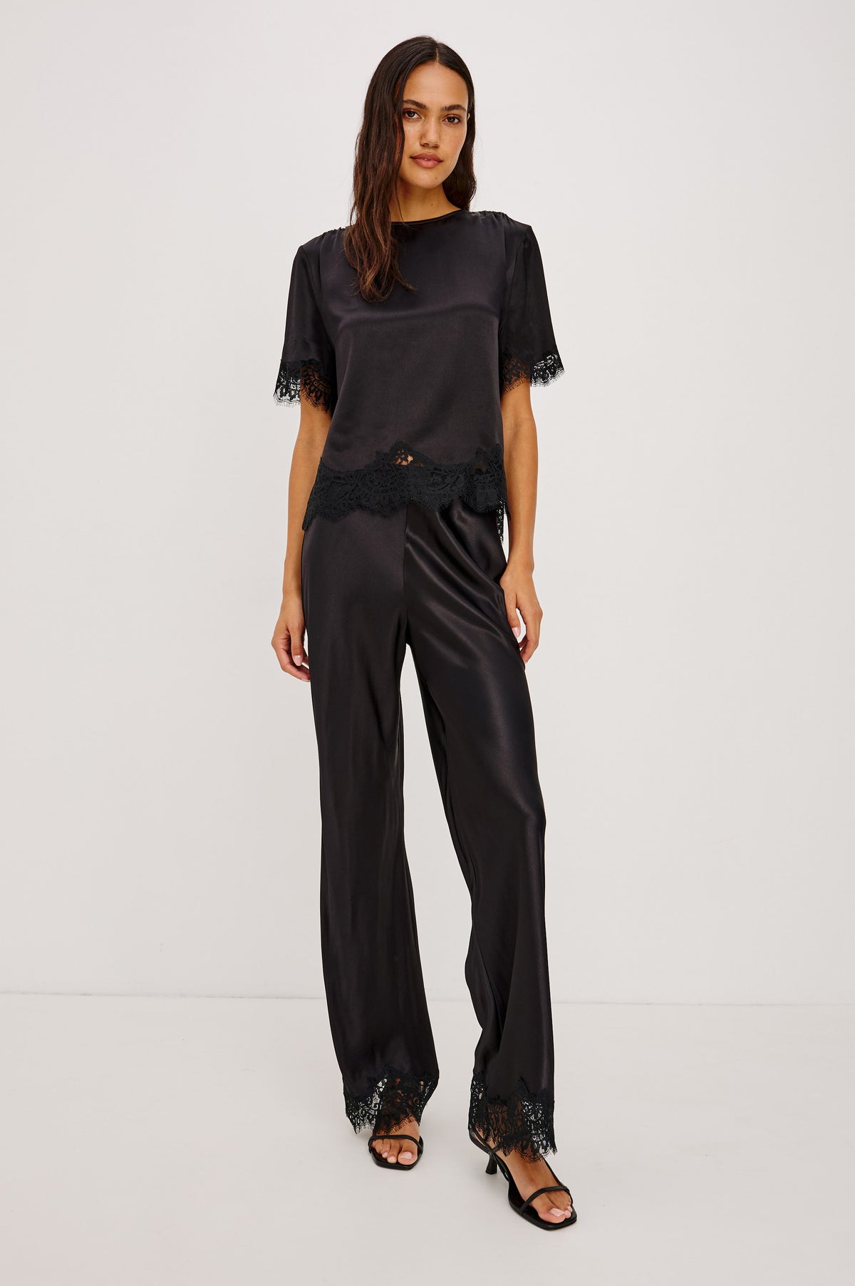Silvi Pant in Satin-Back Crepe With Straight Legs, Elastic Waist, and Lace Hem in Black Colorway - Front Full Body View Featured on Model.