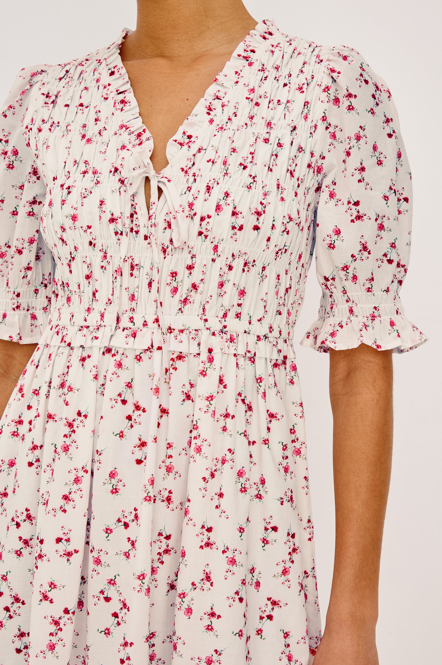 Sonica Midi Dress in Cotton With Fitted Smocked Bodice V-Neckline With Self-Ties Short Puff Sleeves and Single Tiered A-Line Skirt in Rouge Romantic Colorway - Full Body Front View Featured on Model