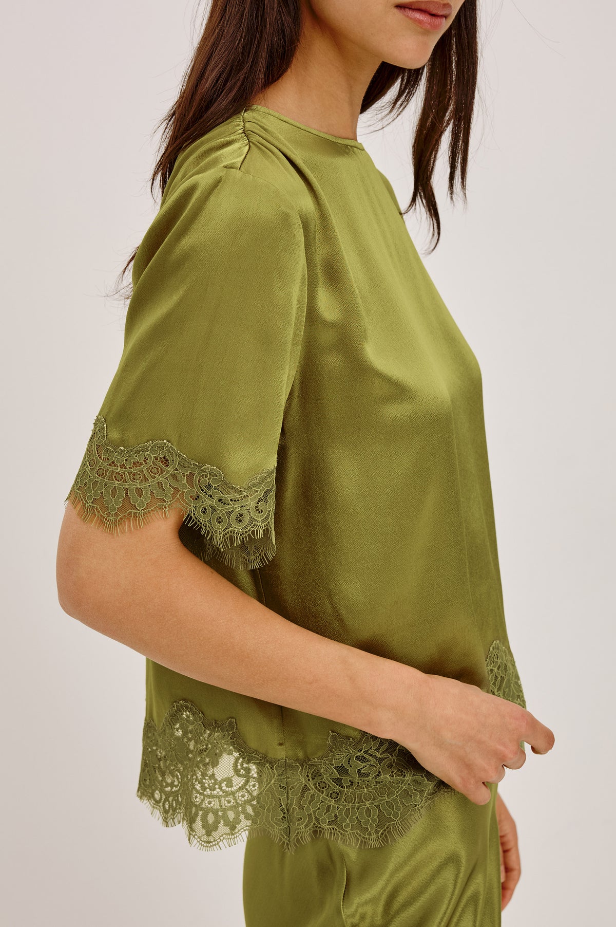 Sonora Shirt in Satin Blend With Loose Boxy Fit, Crew Neck, Shirred Shoulders, Short Sleeves, Button-Loop Back Keyhole, and Lace Trim in Celery ColorwayUpper Body Front Detail View Featured on Model.