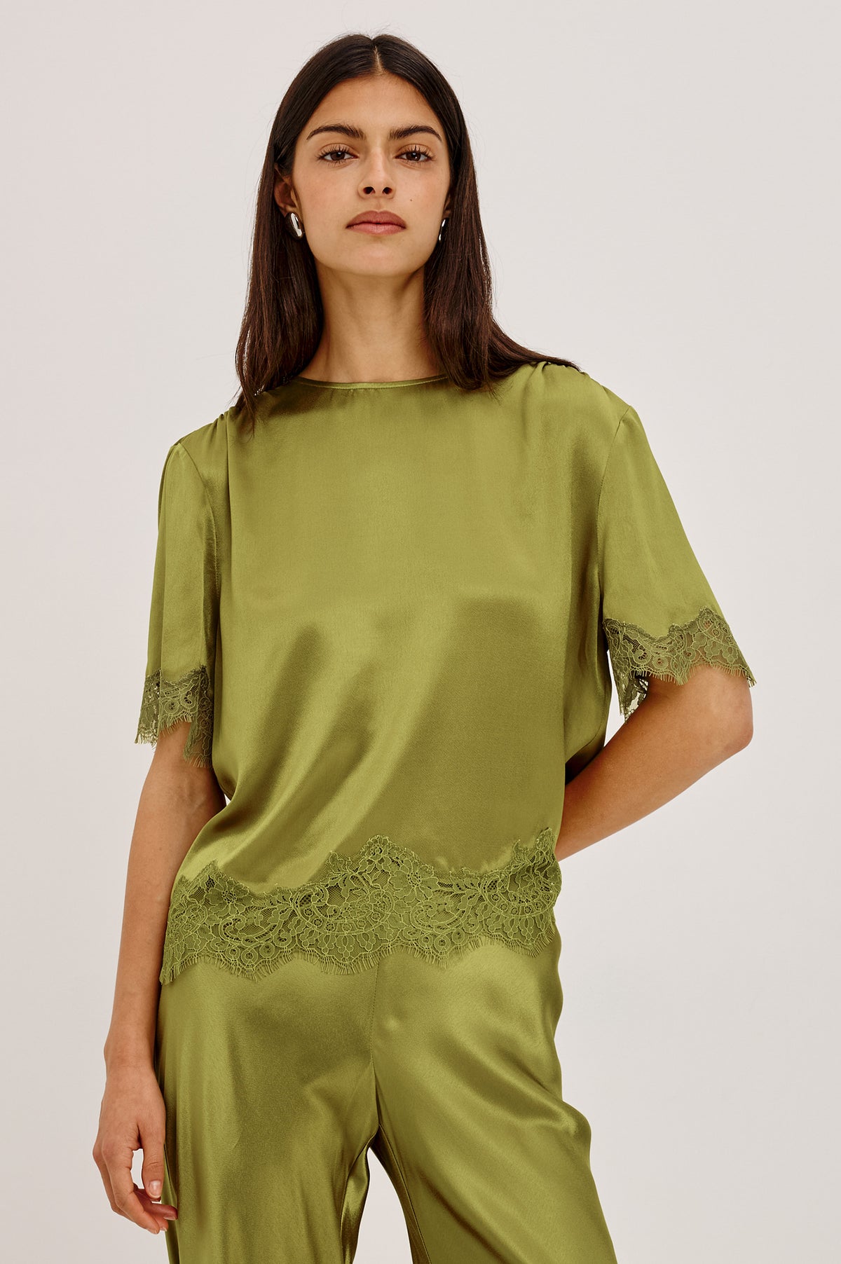 Sonora Shirt in Satin Blend With Loose Boxy Fit, Crew Neck, Shirred Shoulders, Short Sleeves, Button-Loop Back Keyhole, and Lace Trim in Celery ColorwayFront View Featured on Model.